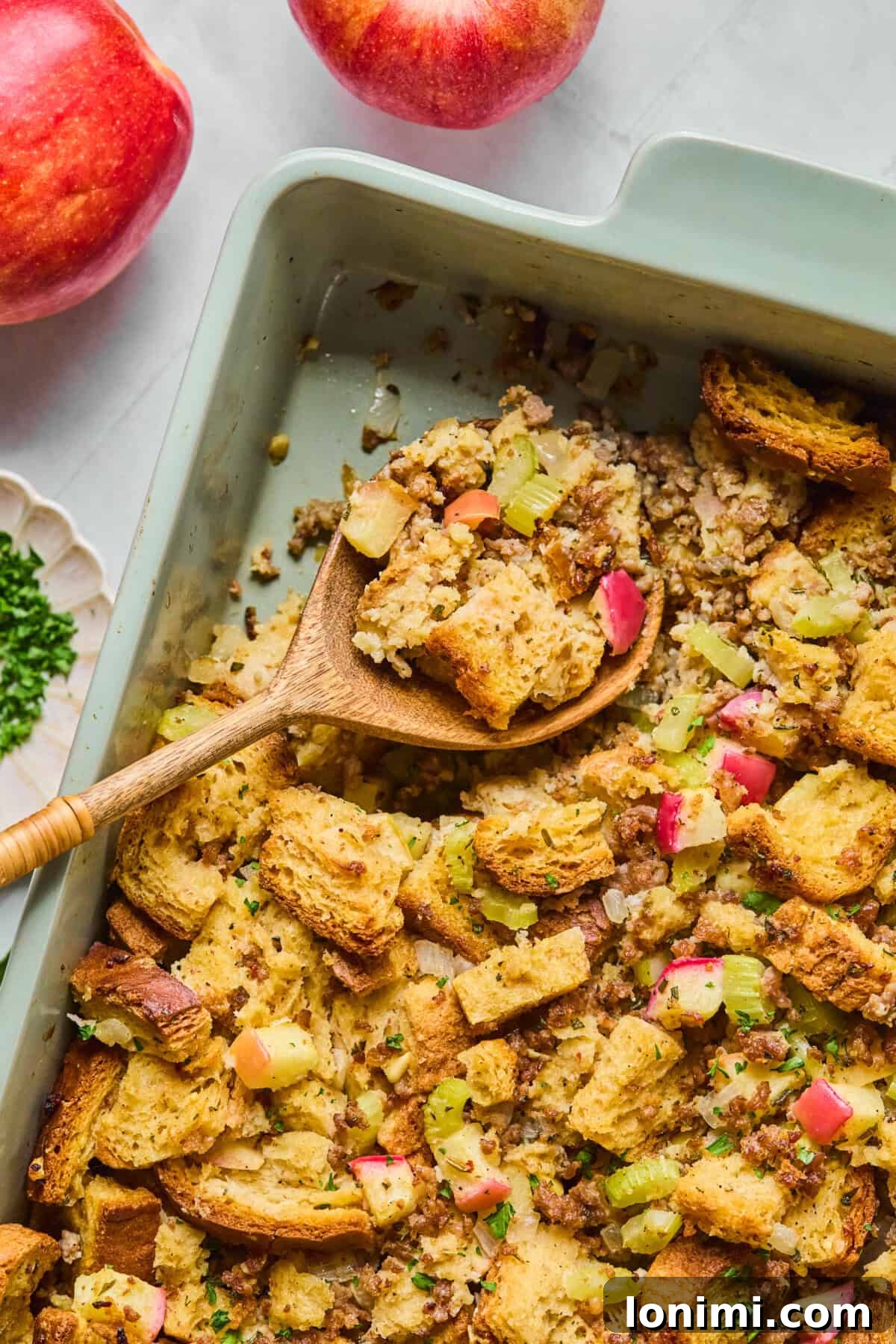 gluten free stuffing in a casserole dish with a wooden spoon