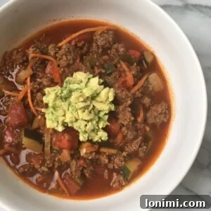Whole30 Veggie Loaded Beef Chili in a bowl, topped with avocado