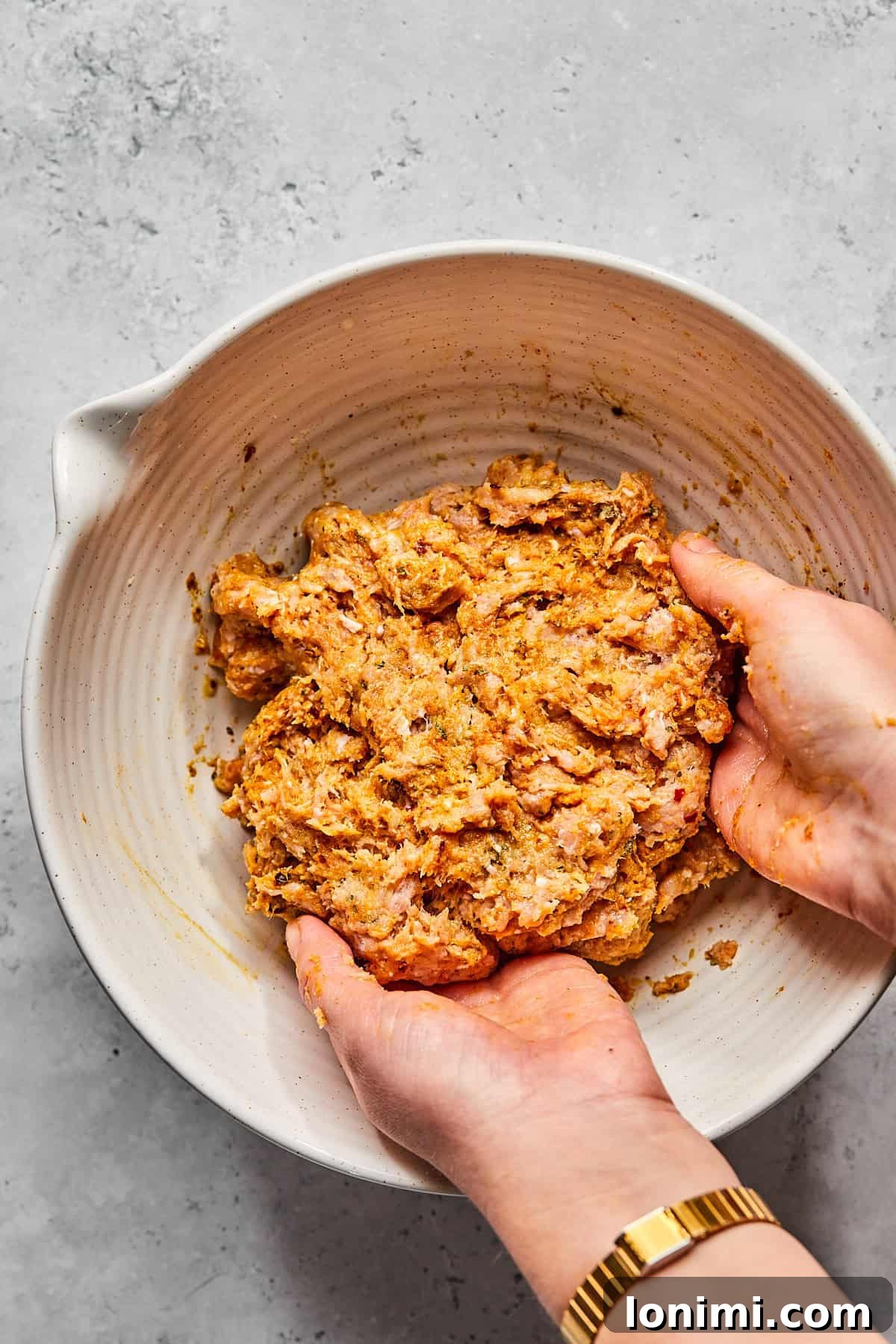 mixing the meatball mixture in a large bowl 