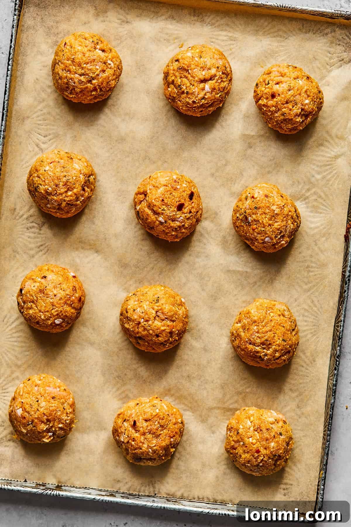 uncooked meatballs on a baking sheet 