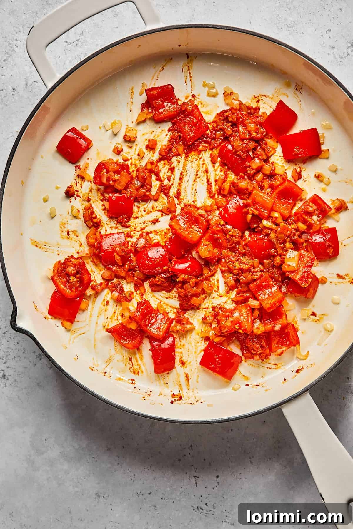 onions and peppers mixed with curry paste in a skillet 