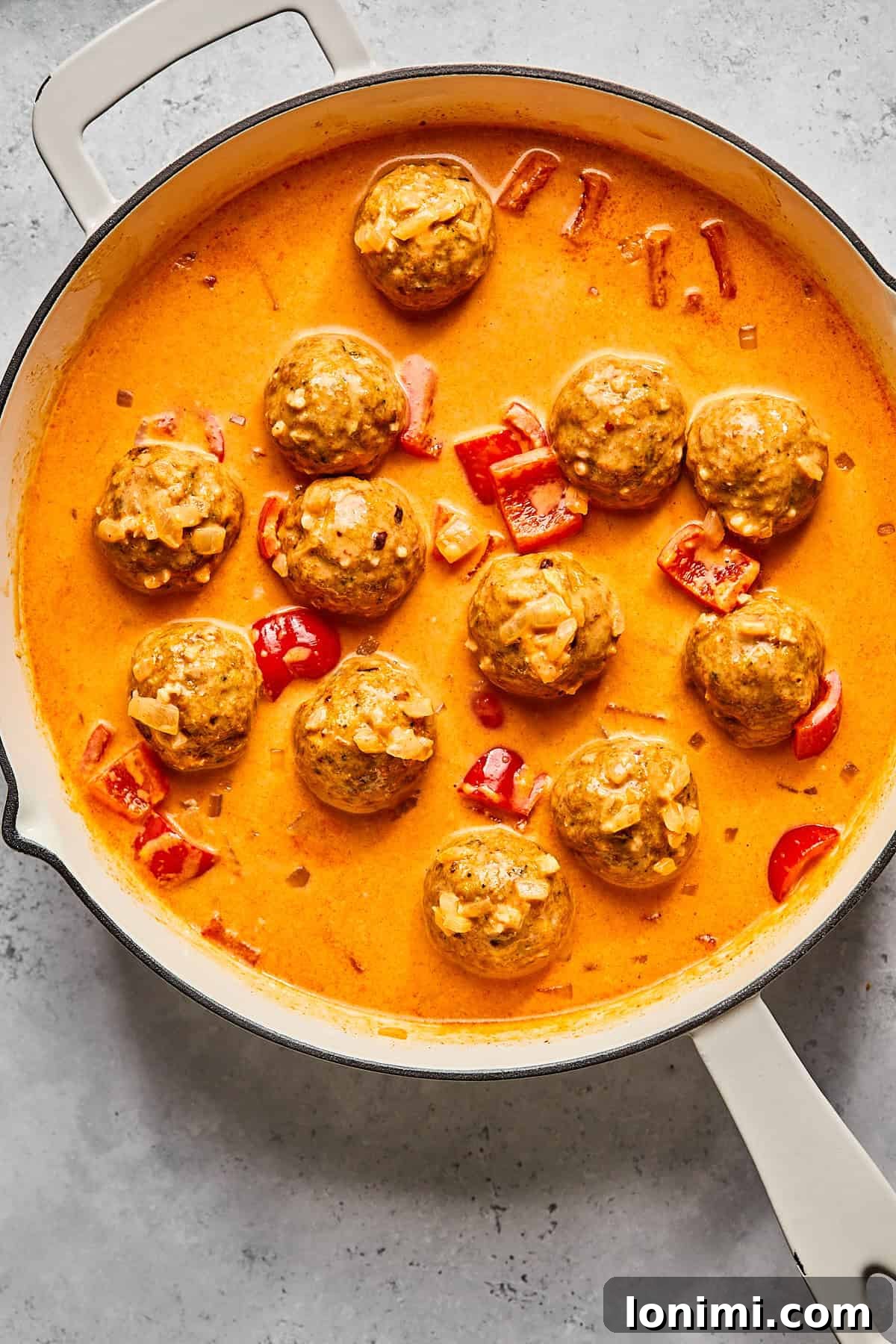 adding cooked meatballs to the thai curry 