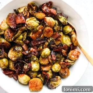 Soy-glazed Brussels sprouts with bacon in a serving bowl.