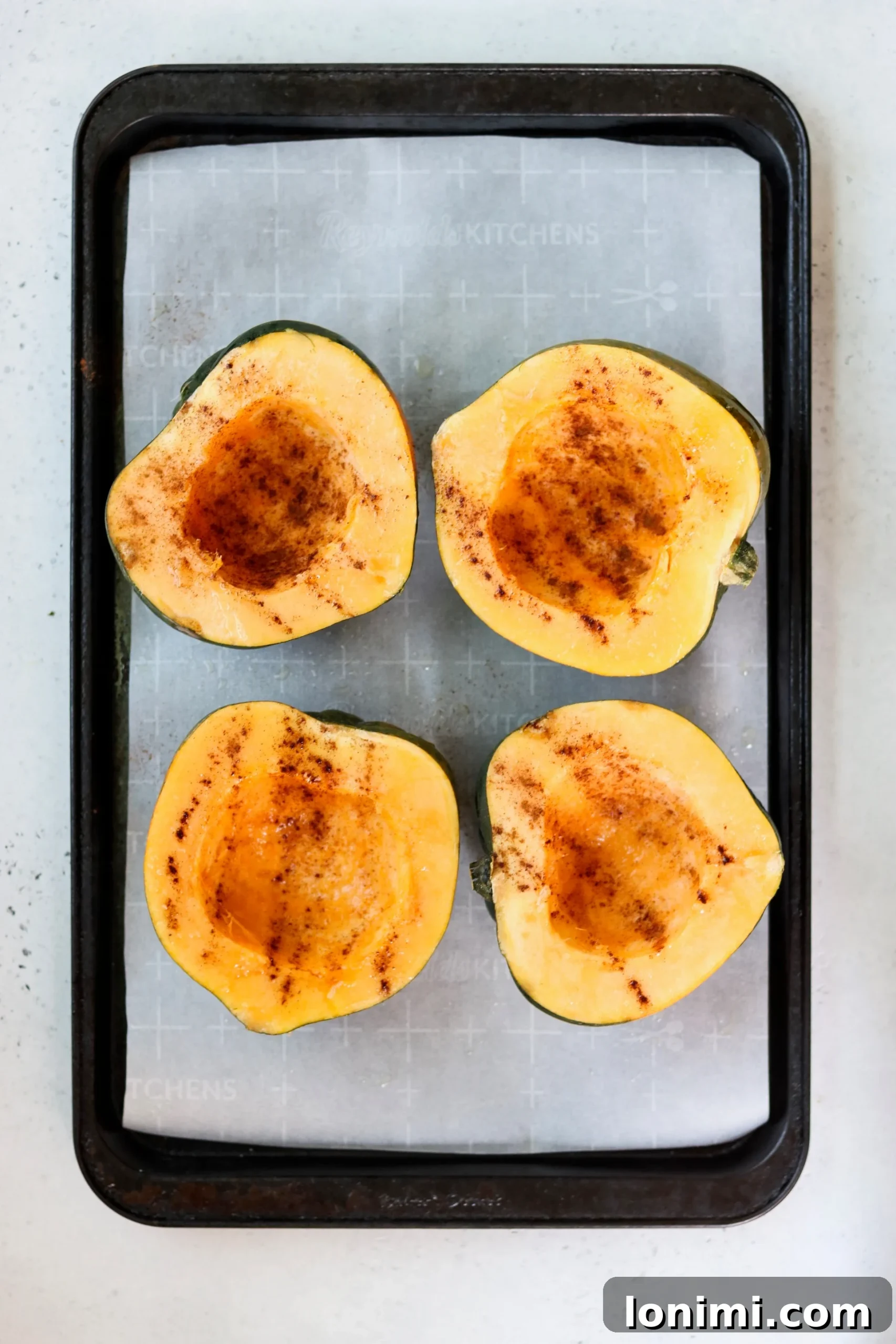 Close-up of a single roasted acorn squash half, brimming with a colorful stuffing of meat, kale, and apples