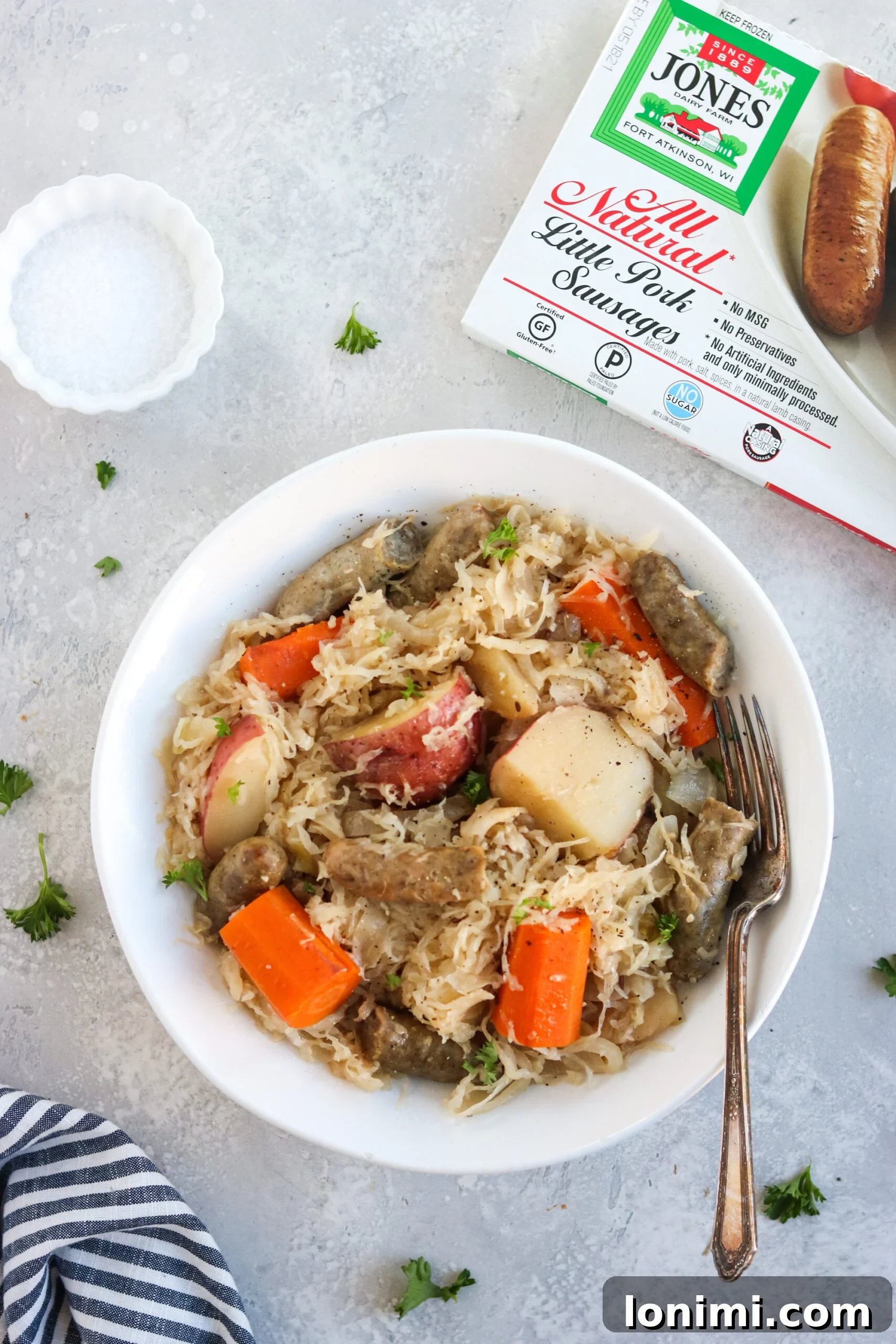 Slow Cooker Sweet and Savory Sausage with Apples and Sauerkraut 6 All the raw ingredients for Slow Cooker Sausage, Sauerkraut, and Apples laid out on a cutting board.