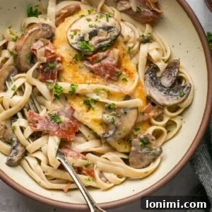chicken marsala fettuccine in a bowl with a fork