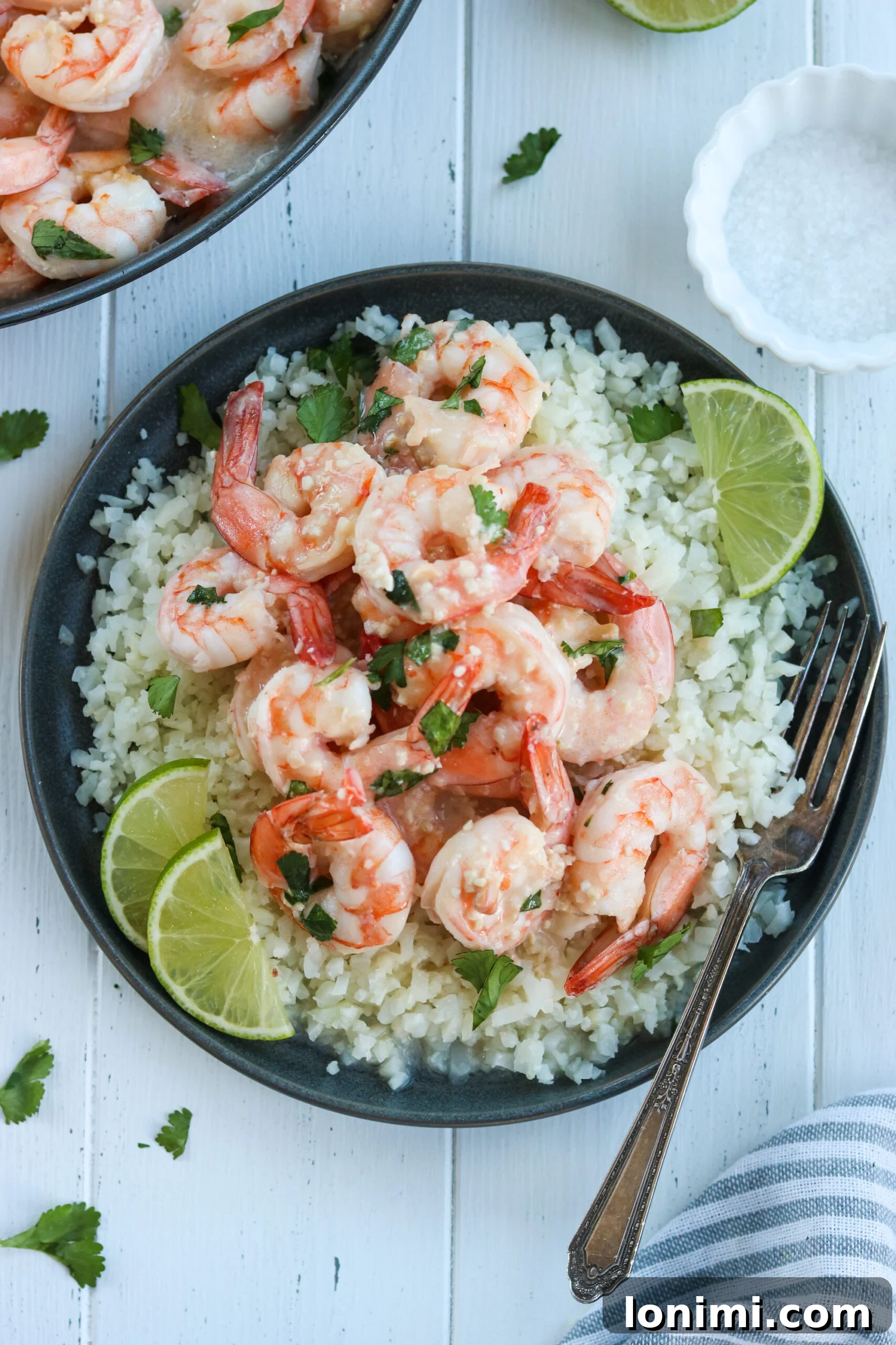 Zesty Whole30 Coconut Lime Shrimp 3 Close-up shot of pan-seared shrimp sizzling in a skillet, coated in a rich, creamy sauce.