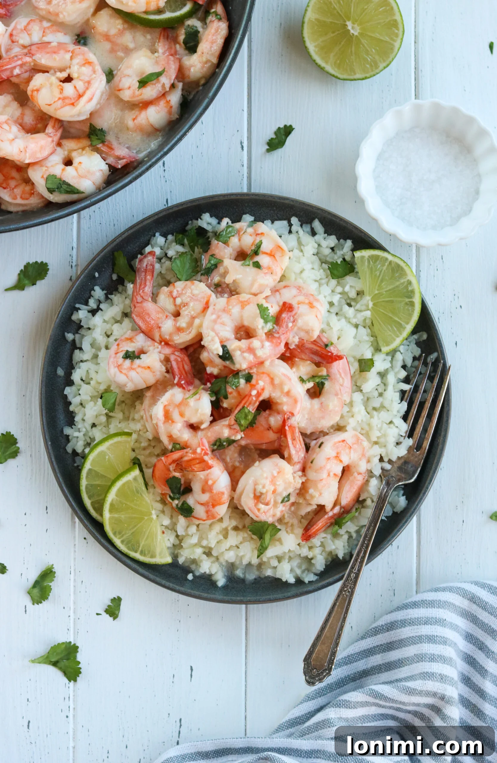Zesty Whole30 Coconut Lime Shrimp 4 A vibrant close-up of the Whole30 Coconut Lime Shrimp Skillet, featuring perfectly cooked shrimp in a creamy, green-hued sauce, garnished with fresh cilantro and lime wedges.