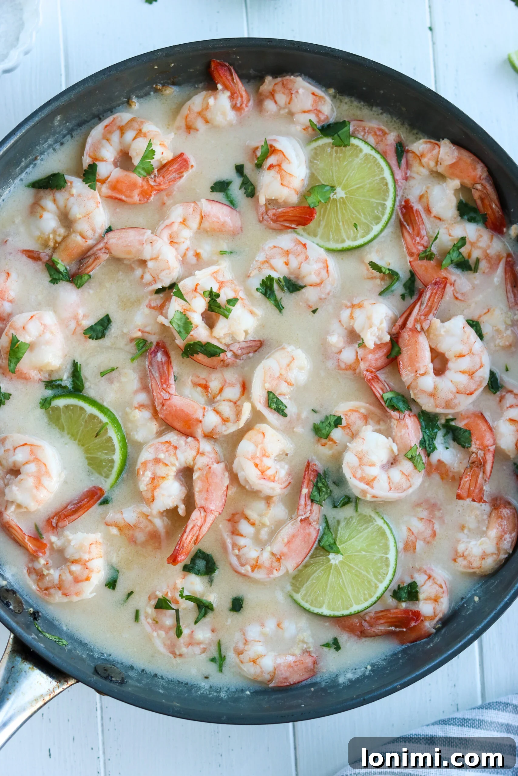 Zesty Whole30 Coconut Lime Shrimp 6 A close-up shot of two hands holding forks, about to enjoy a serving of Whole30 Coconut Lime Shrimp over cauliflower rice.