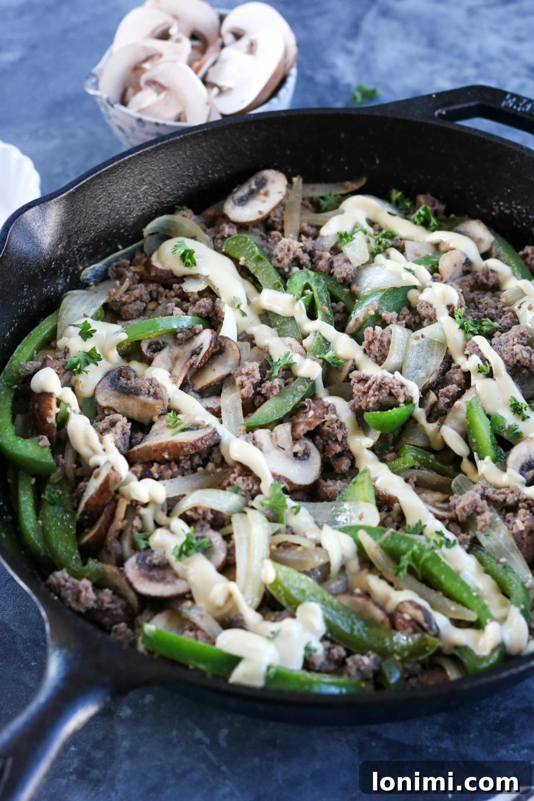 A delicious serving of Whole30 Philly Cheesesteak Skillet on a plate, garnished with fresh herbs, showcasing the vibrant colors and hearty ingredients.