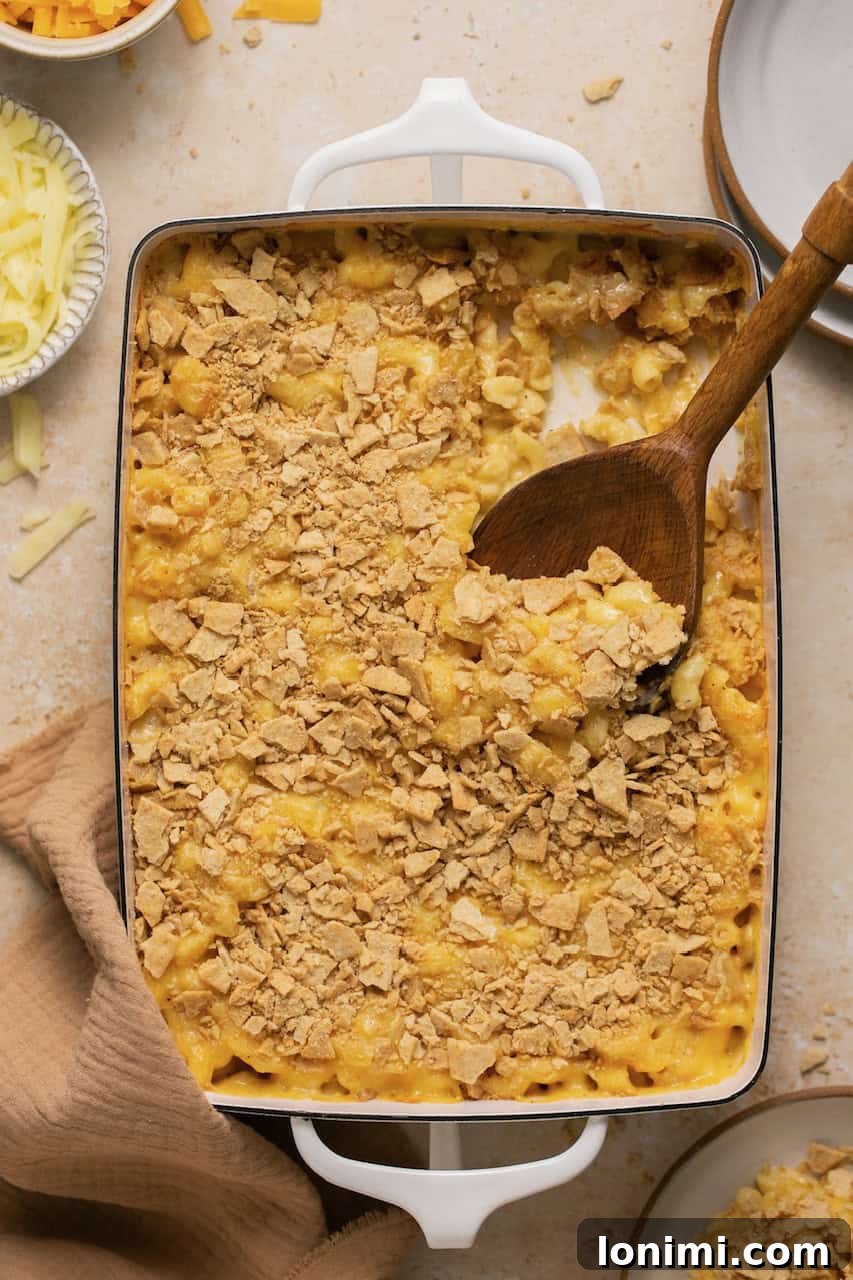 No-Fuss Gluten-Free Oven-Baked Mac and Cheese Perfection 7 Baked gluten-free mac and cheese in a casserole dish with a serving spoon taking out a scoop.