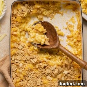 No-Fuss Gluten-Free Oven-Baked Mac and Cheese Perfection 10 Gluten free mac and cheese topped with crackers in a casserole dish with a serving spoon taking a scoop out