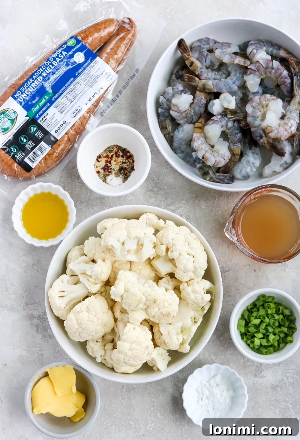 Ingredients for Keto Shrimp and Grits - raw shrimp, cauliflower florets, kielbasa, green onions, broth, spices, and ghee