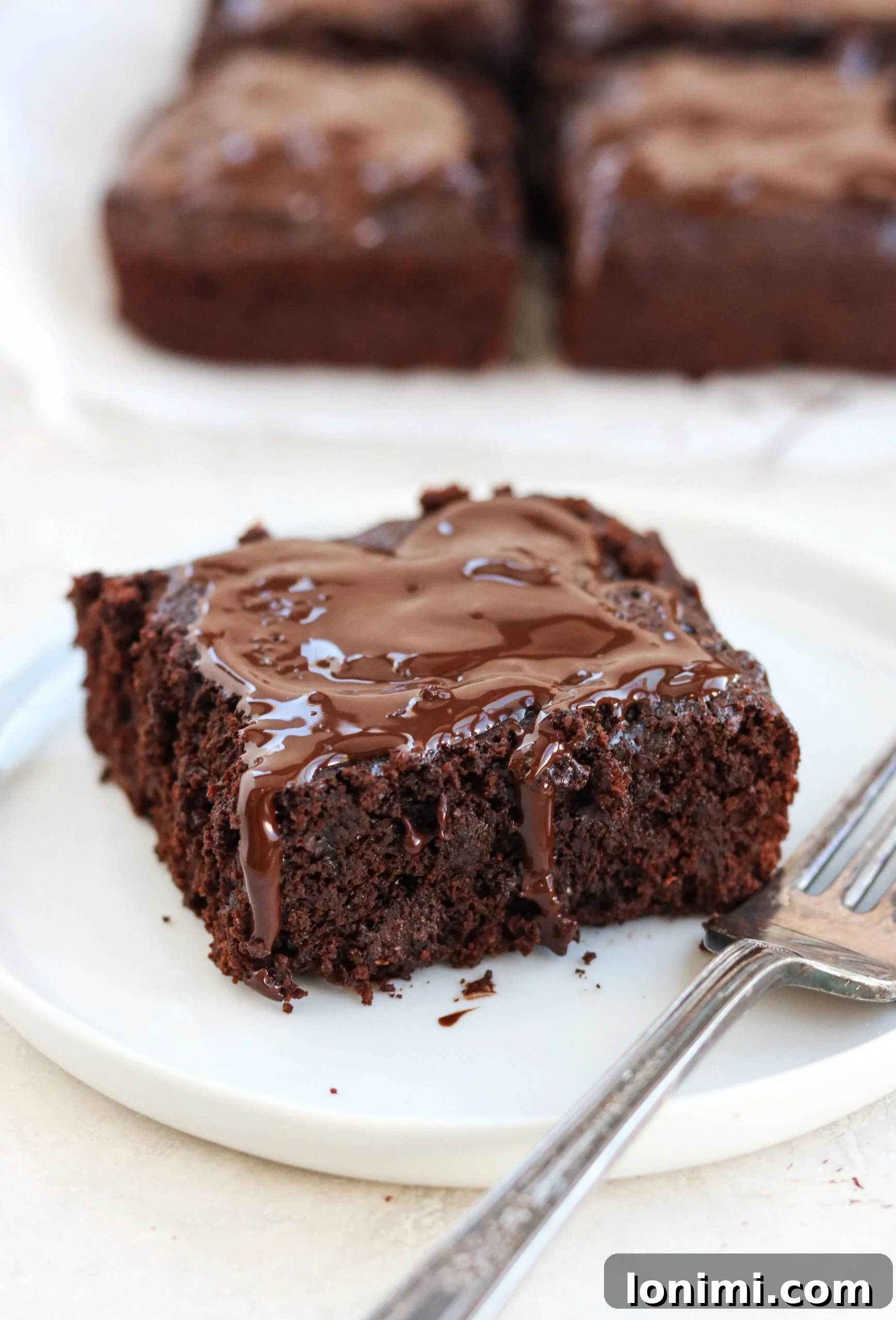 A close-up shot of several Paleo Double Chocolate Thin Mint Brownies, highlighting their moist, dense interior and glistening chocolate topping.
