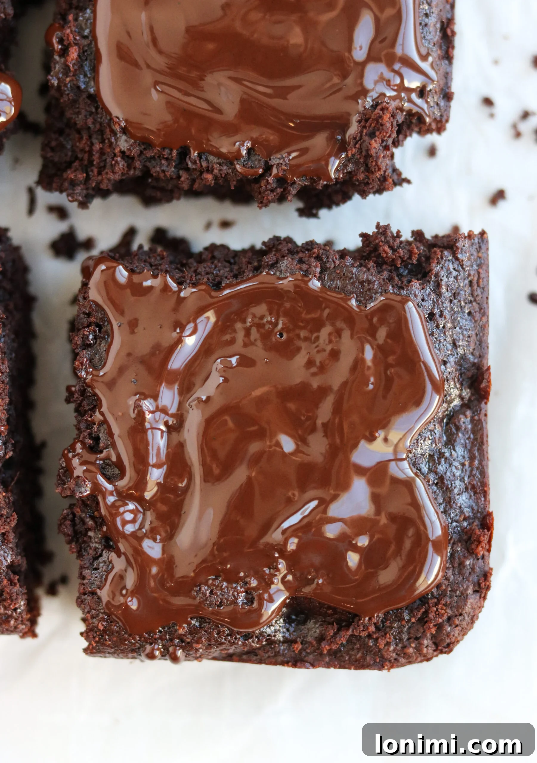 A single slice of a rich Paleo Double Chocolate Thin Mint Brownie, showing off its dense, fudgy texture and a delicate chocolate drizzle on top.