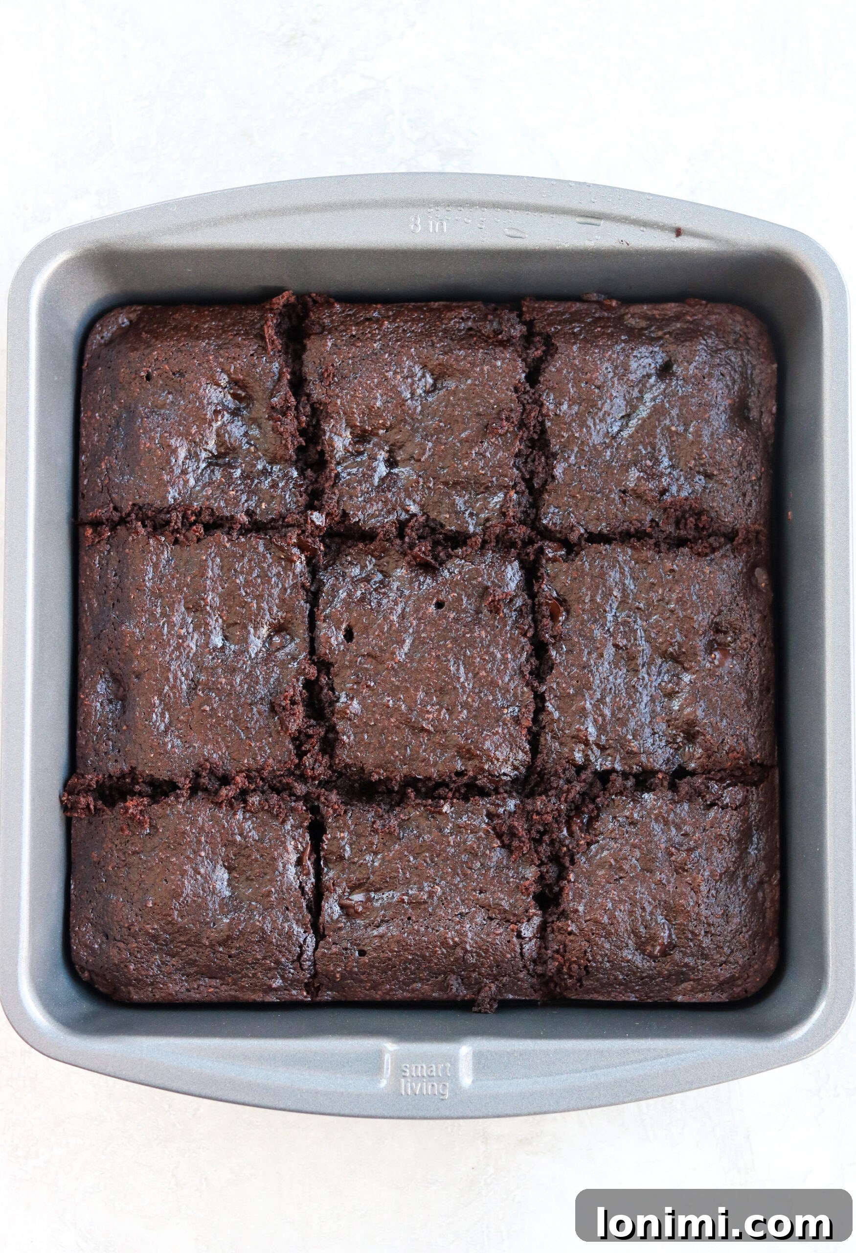 A baking pan filled with freshly baked Paleo Double Chocolate Thin Mint Brownies, cooling on a wire rack.