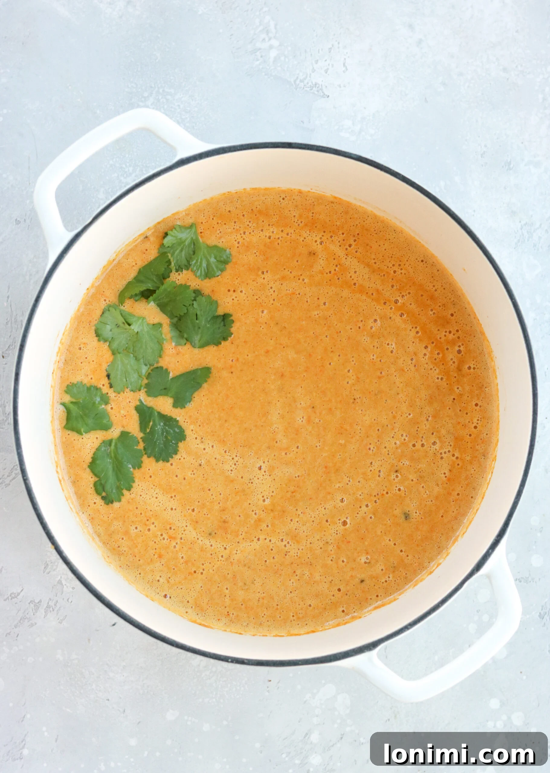 Delicious and creamy curried cauliflower carrot soup presented in a white bowl, ready to be enjoyed.