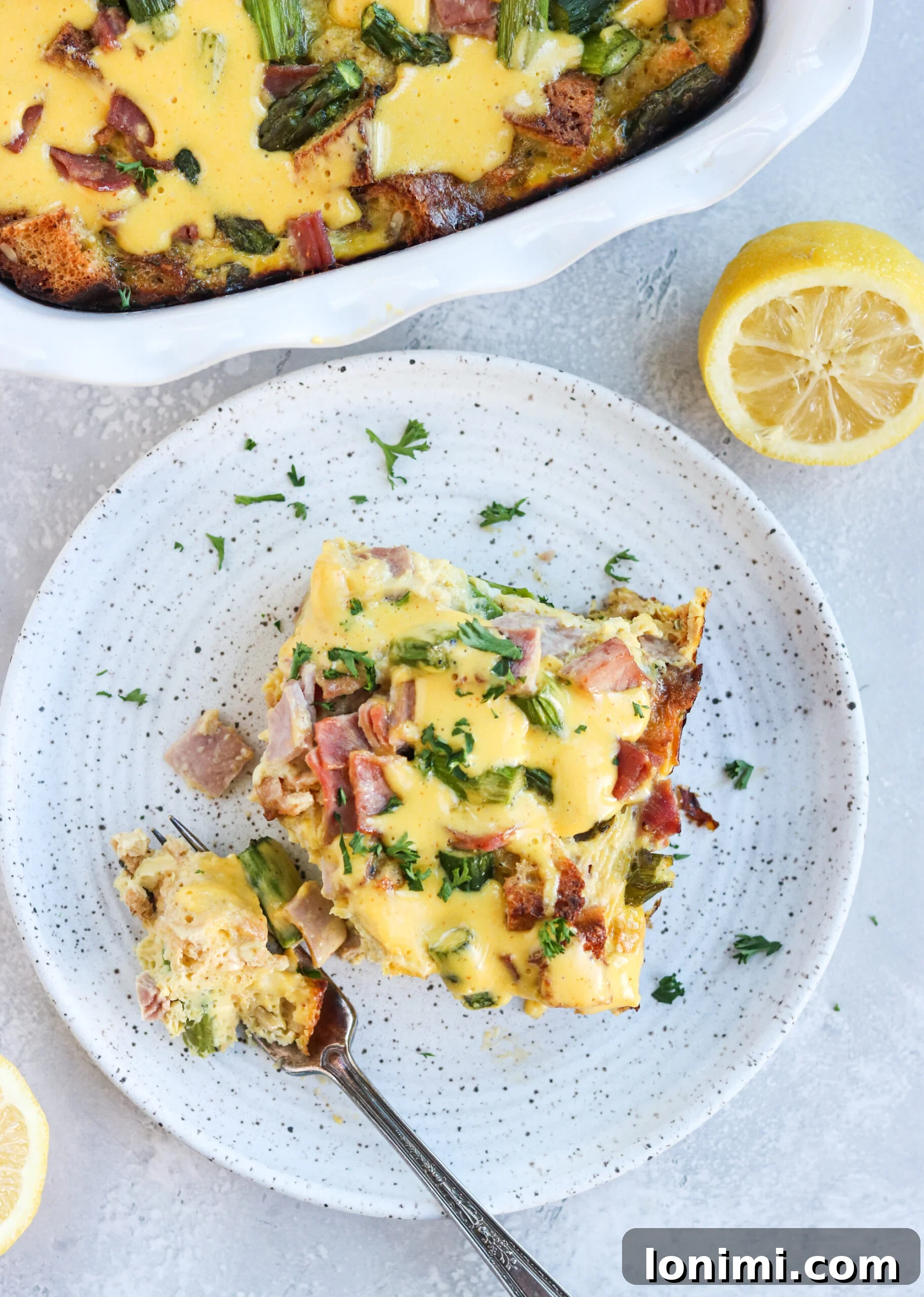 Delicious Gluten-Free Eggs Benedict Casserole with a fork on a plate, ready to be served for brunch.