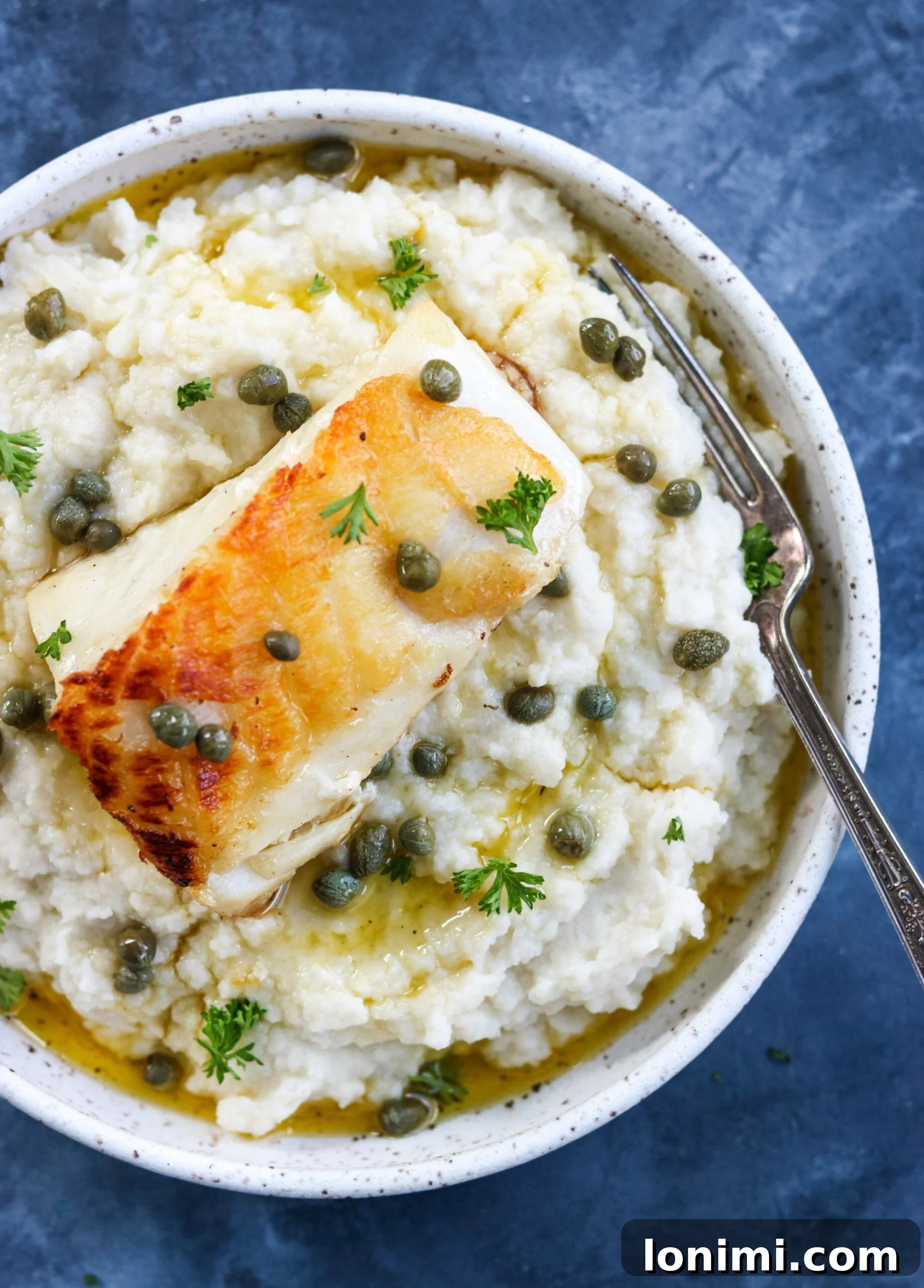 Top view of Pan Seared Chilean Sea Bass with Lemon Caper Butter beautifully arranged on a serving dish, highlighting the vibrant colors and appealing presentation.
