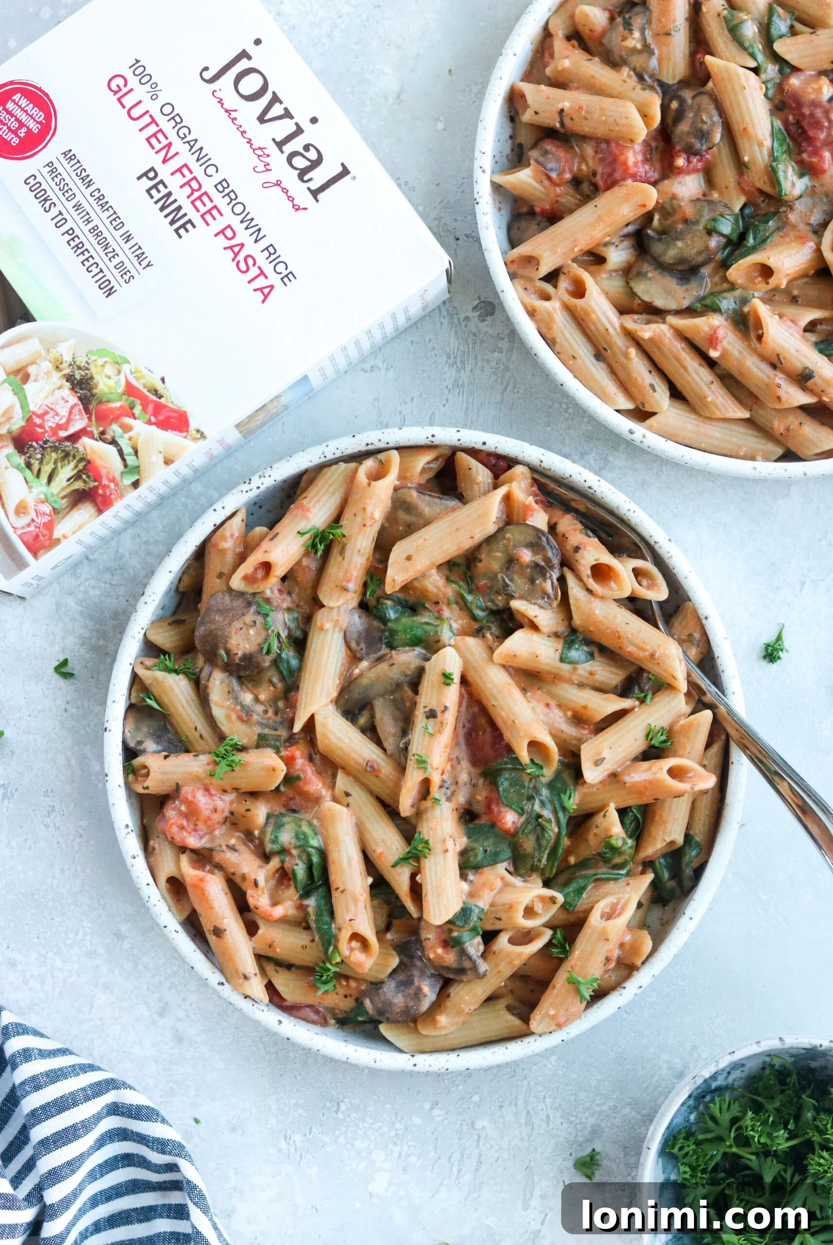 Instant Pot Creamy Tomato Penne on a white bowl and a recipe book