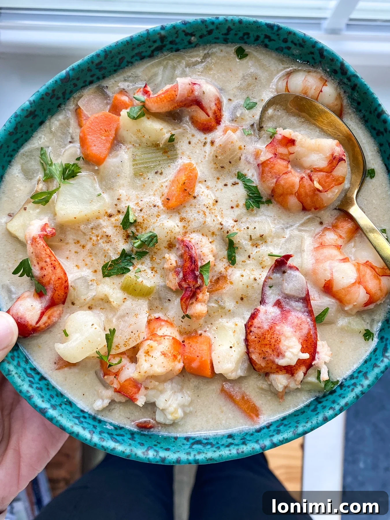 Seafood chowder soup A rustic bowl filled with creamy seafood chowder, artfully arranged on a wooden surface, with a spoon revealing the rich texture and variety of seafood.