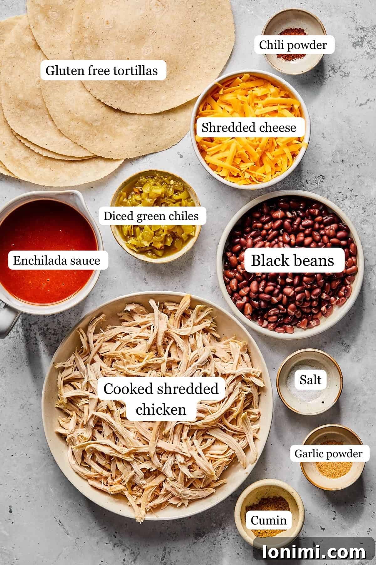 Weeknight Chicken and Black Bean Enchiladas 3 A collection of small bowls displaying recipe ingredients like shredded chicken, black beans, diced green chiles, various spices, and a jar of enchilada sauce.