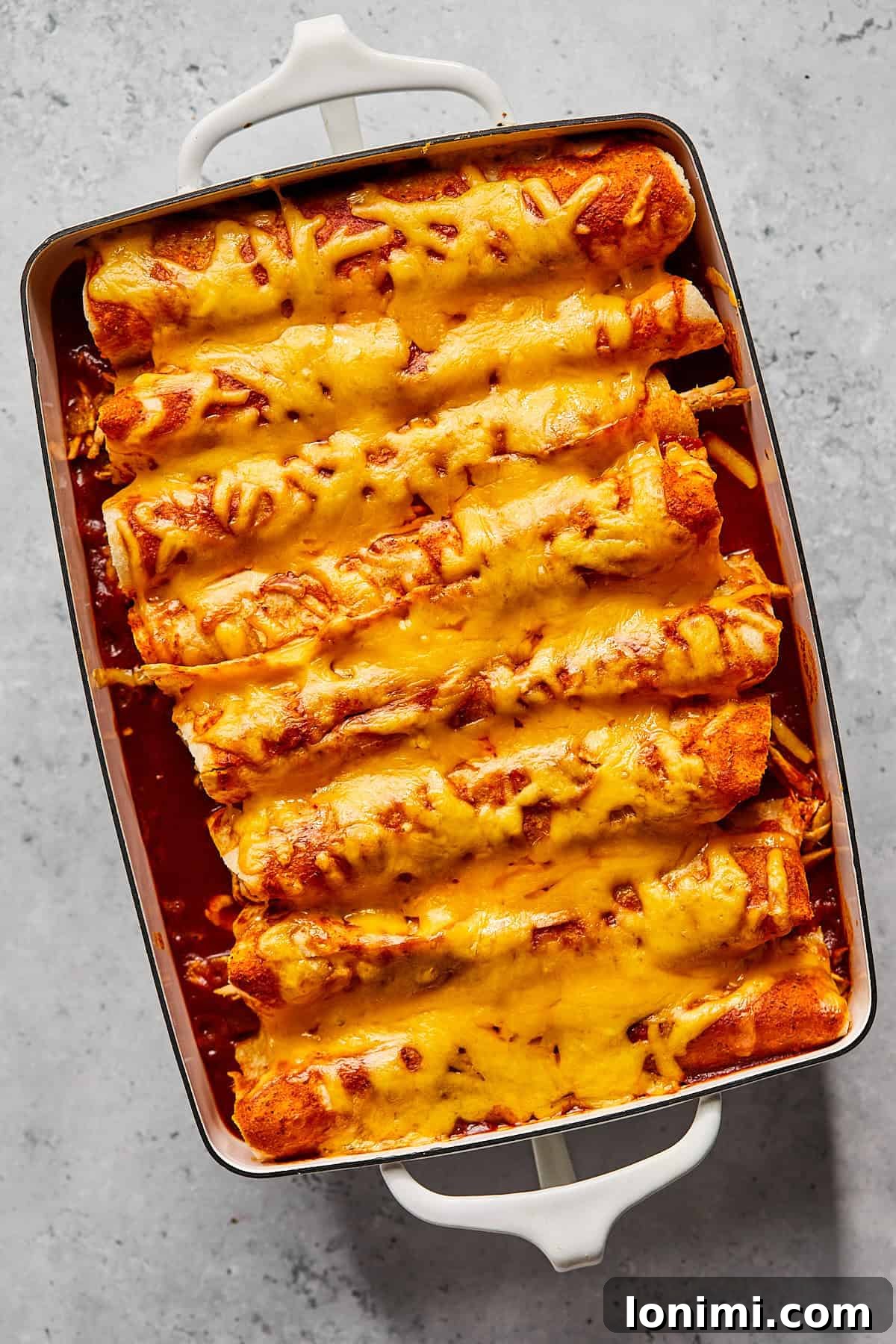 Weeknight Chicken and Black Bean Enchiladas 8 A freshly baked casserole dish of chicken and black bean enchiladas, golden brown and bubbling with melted cheese, just out of the oven.