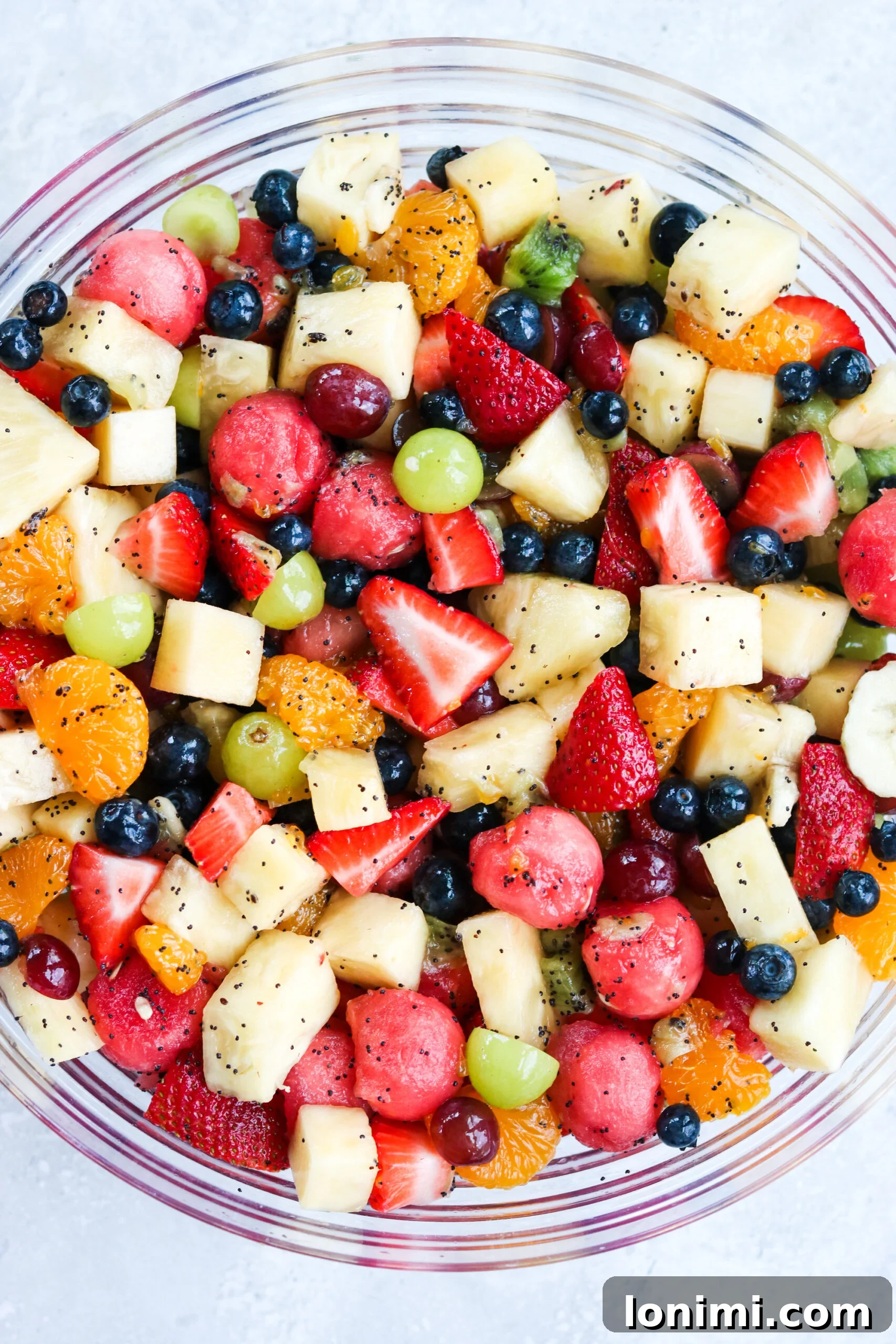 Closeup image of a bowl of Honey Lime Poppyseed Fruit Salad, highlighting the vibrant colors and fresh ingredients.