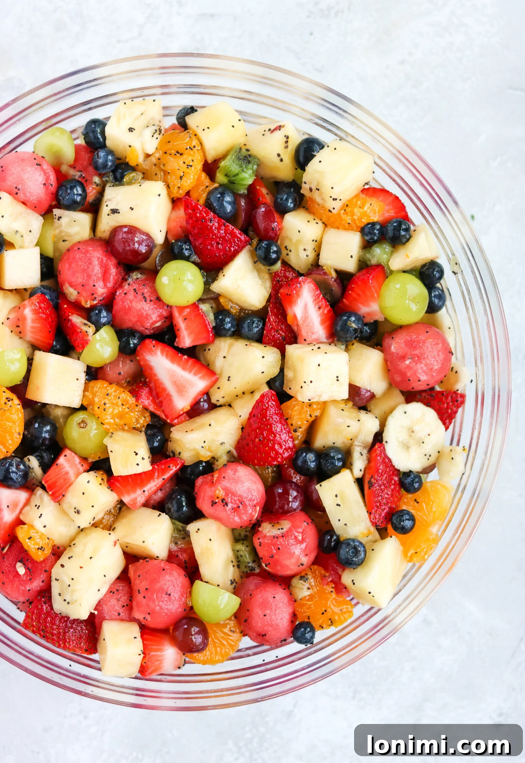 A large, inviting bowl filled with an assortment of freshly cut fruits, ready to be dressed.
