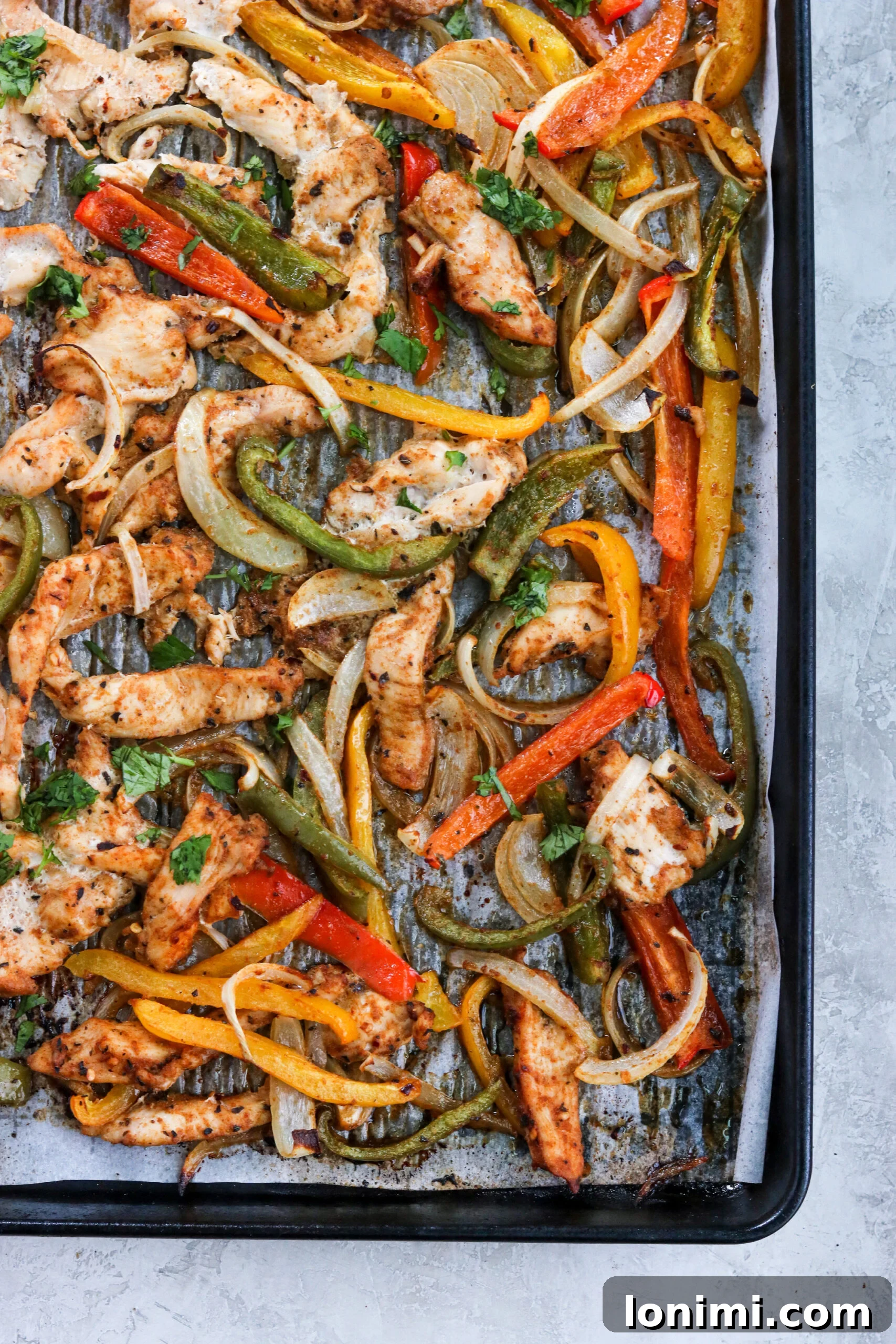 Sheet pan chicken fajitas, vibrant and perfectly cooked on a baking sheet