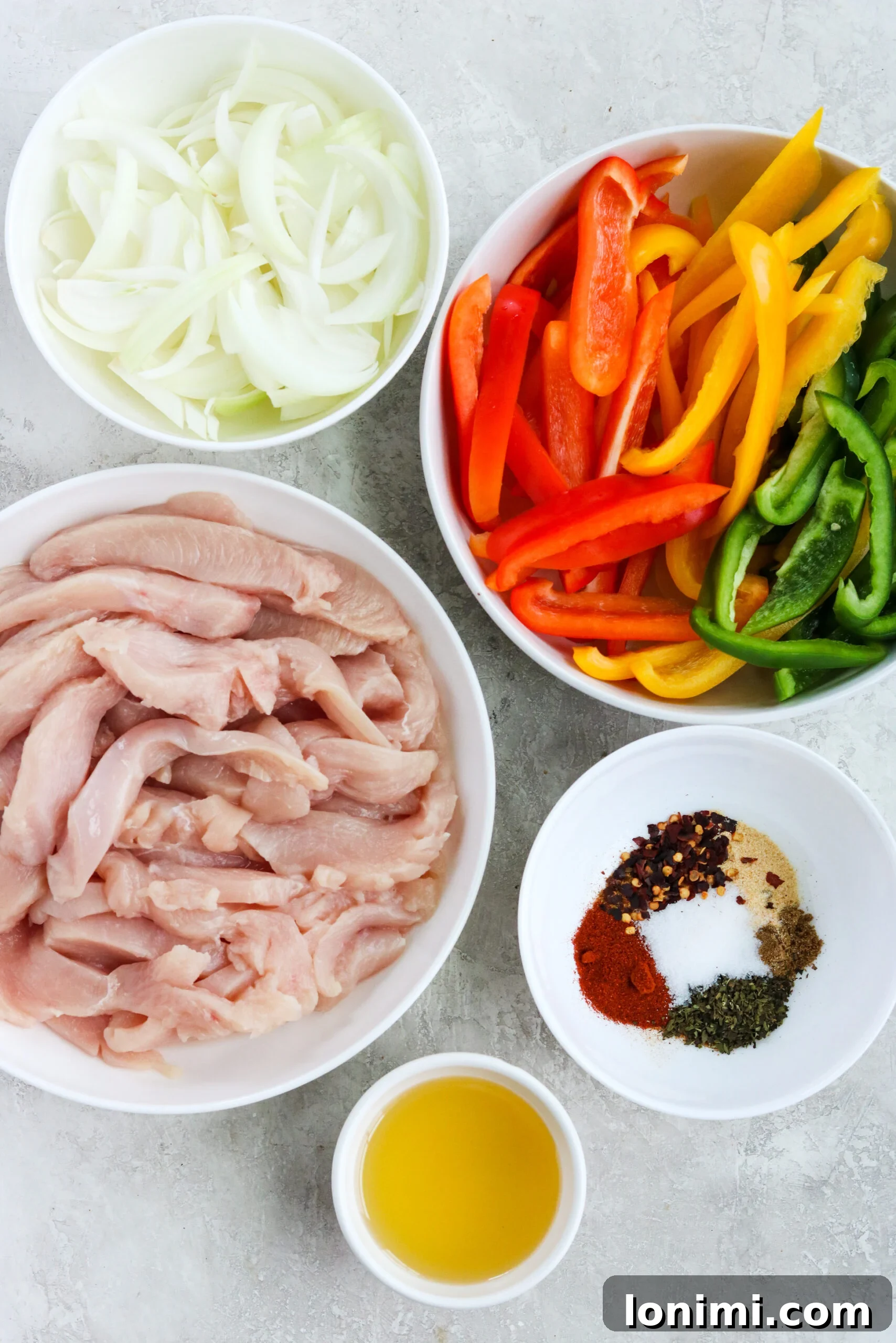 Ingredients for easy sheet pan chicken fajitas laid out on a kitchen counter