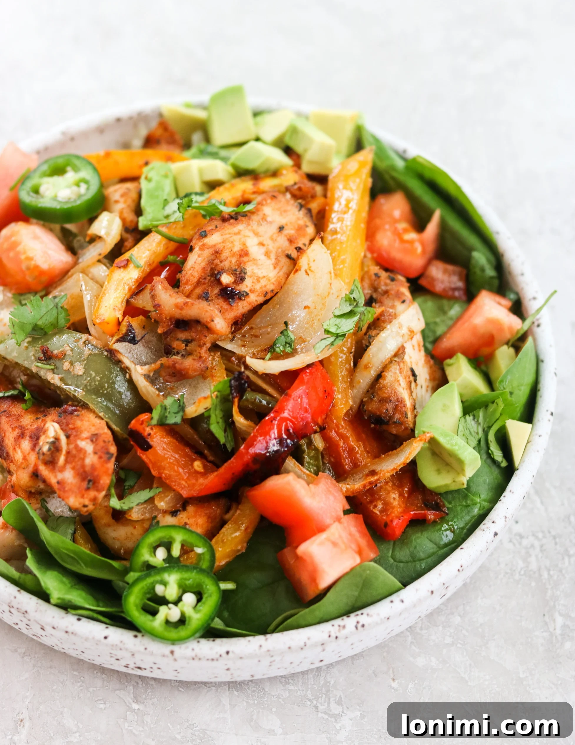 Healthy baked chicken fajita bowl with fresh toppings and lime