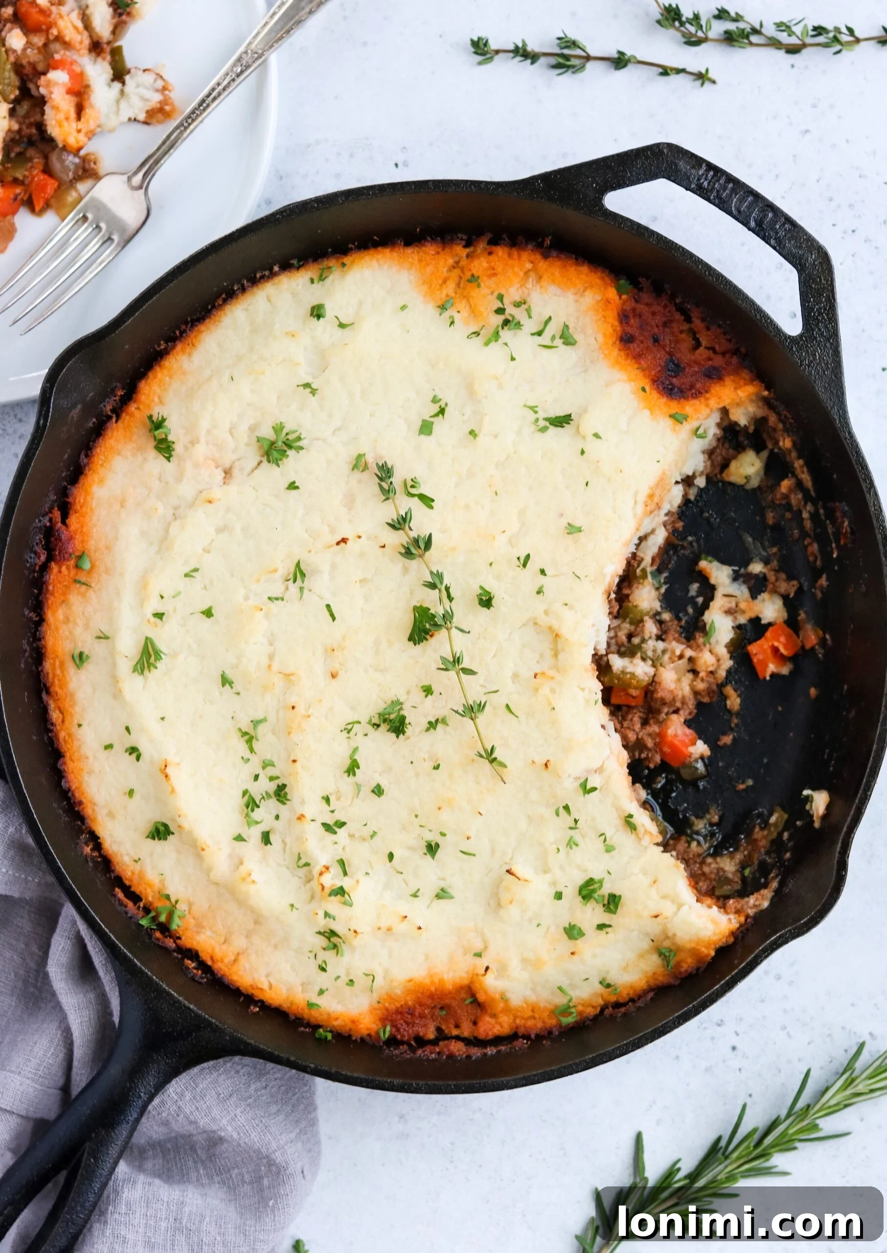 Close-up of Skillet Shepherd's Pie showing the rich beef and vegetable filling beneath the mashed cauliflower