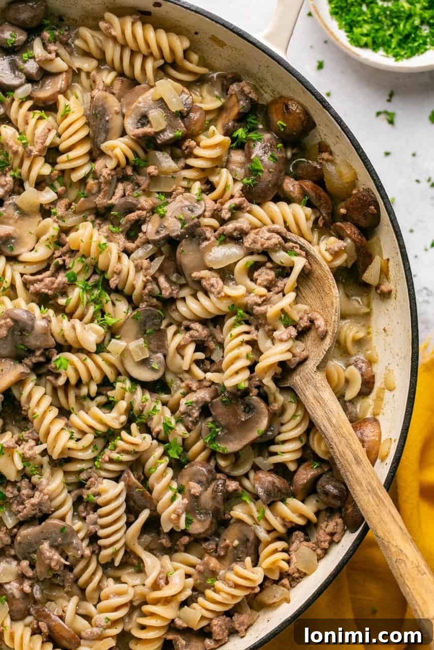 Gluten-free Hamburger Helper Stroganoff in a large pot, with a wooden spoon, ready to be served.