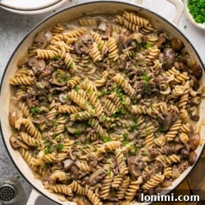 Homemade Hamburger Helper Stroganoff in a pot, topped with fresh parsley.