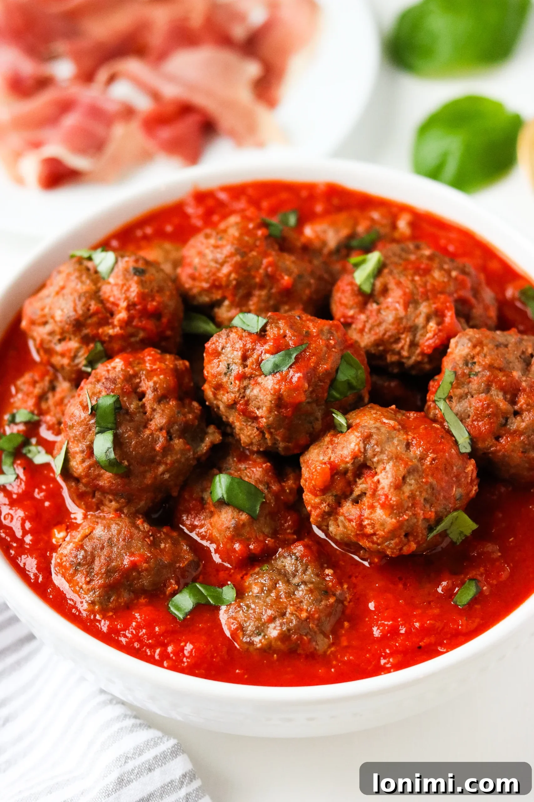 Cooked Prosciutto Meatballs simmering in sauce