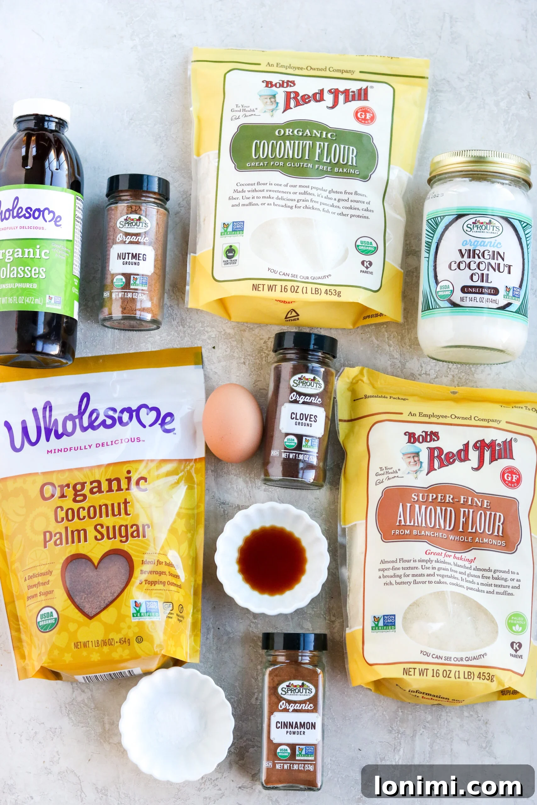 Effortless Gluten-Free Almond Flour Gingersnaps 3 A collection of ingredients laid out, including almond flour, coconut sugar, molasses, spices, and an egg, ready to make almond flour cookies.