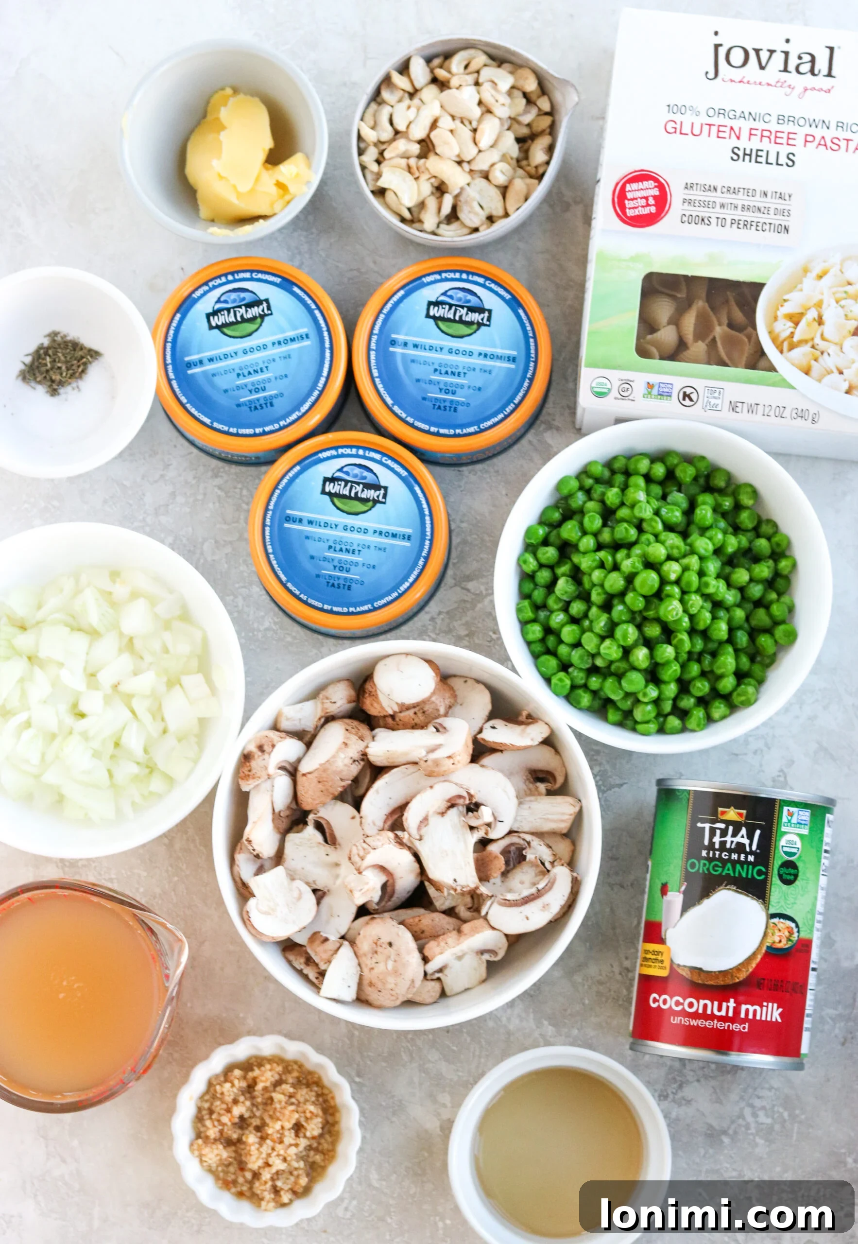 Wholesome Tuna Noodle Bake 3 Ingredients for Healthy Tuna Noodle Casserole laid out on a kitchen counter, including canned tuna, pasta, mushrooms, onions, peas, and cashew cream components.