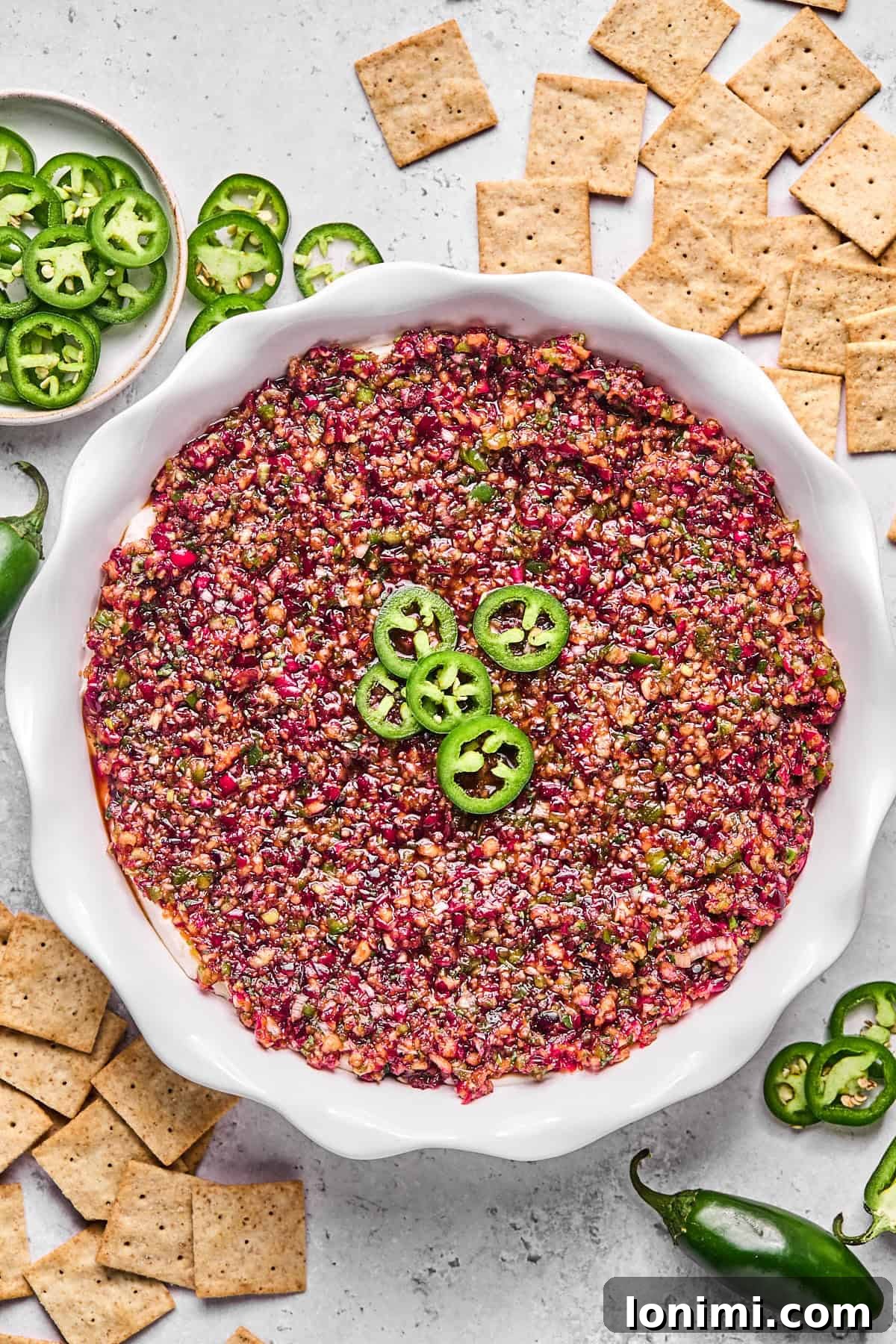 Dairy-Free Cranberry Jalapeno Dip: The Perfect Sweet Heat 10 cranberry jalapeno cream cheese dip in a pie plate surrounded by crackers and jalapenos