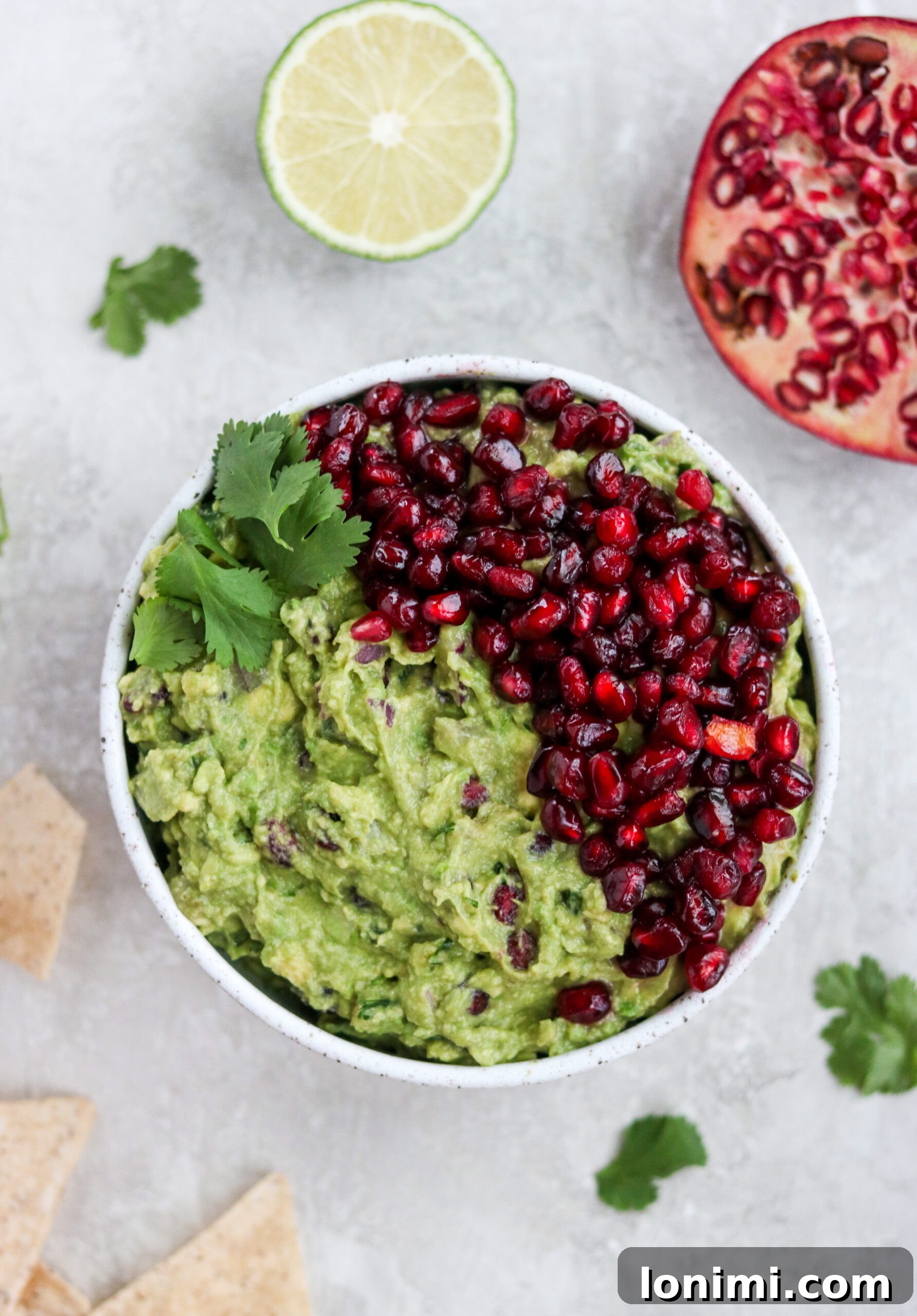 Overhead view of healthy pomegranate guacamole served with tortilla chips
