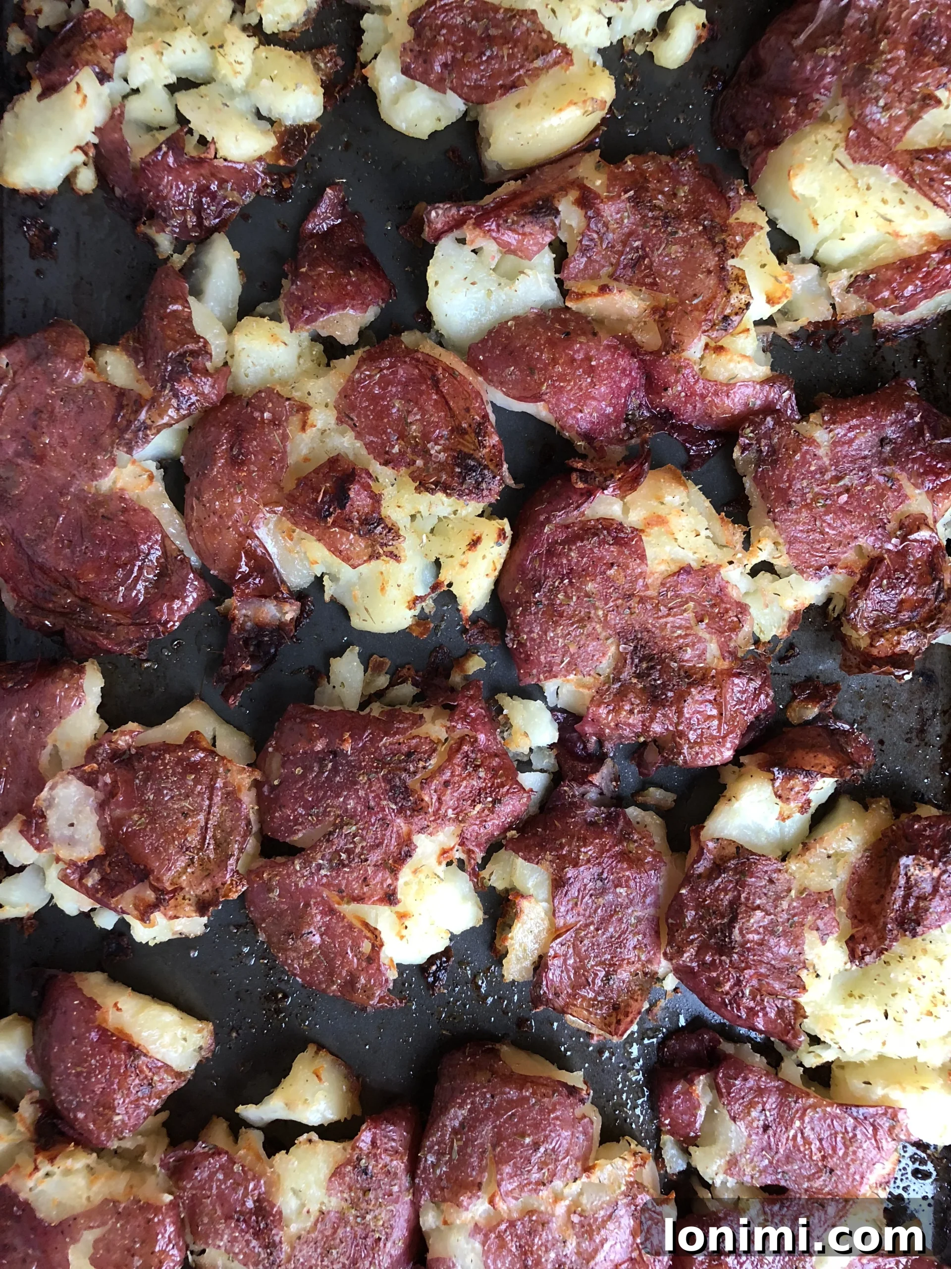 Golden-Crisp Smashed Potatoes with Fragrant Herb Ghee 3 Another view of the crispy smashed potatoes on a baking sheet, ready to be served.