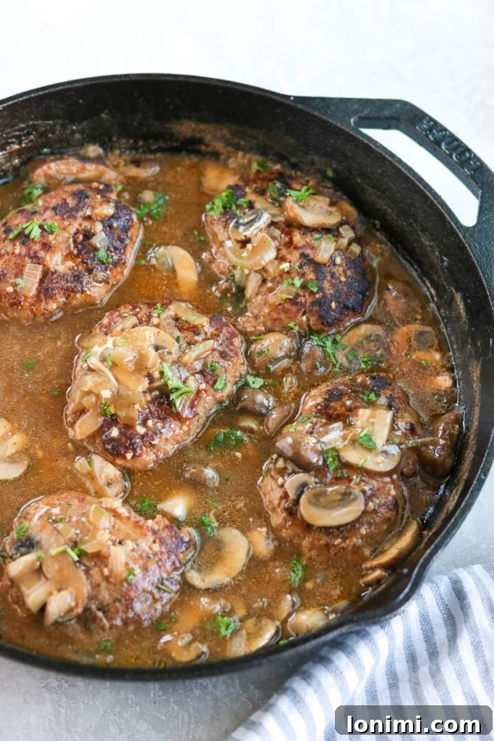 Grandma's Comfort Salisbury Steak with Savory Mushroom Gravy 2 Old-fashioned Salisbury steak with rich mushroom gravy served in a rustic cast iron skillet