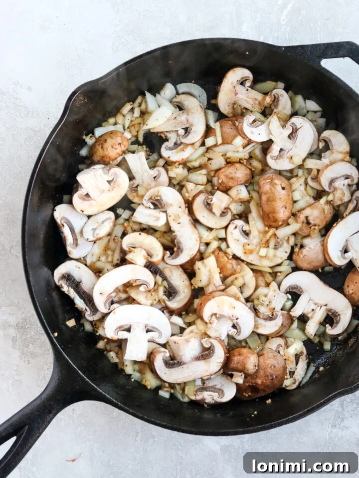 Grandma's Comfort Salisbury Steak with Savory Mushroom Gravy 6 Sautéed mushrooms and onions creating the base for the mushroom gravy in a skillet
