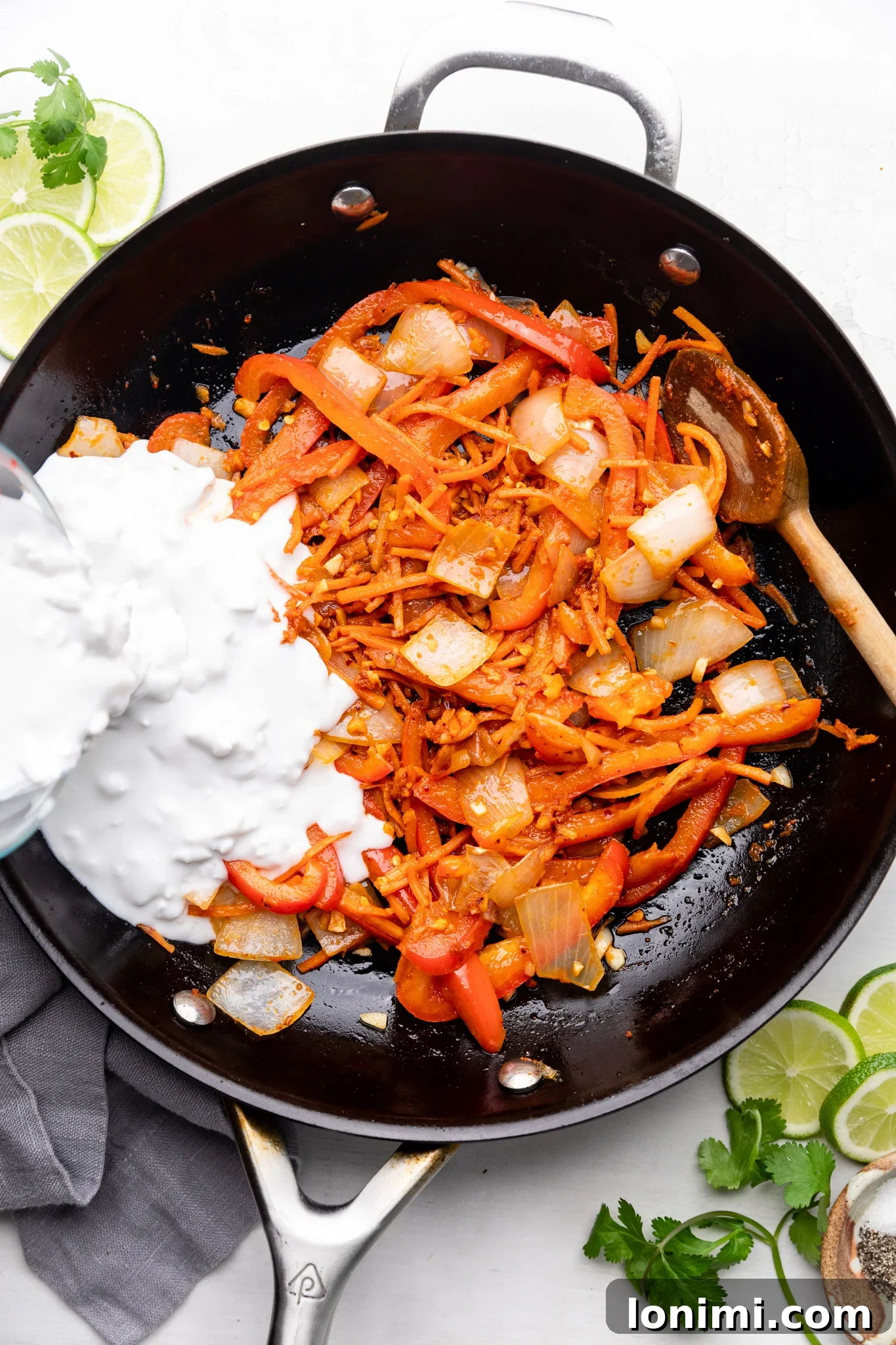 Vibrant ingredients for Thai curry ramen simmering in a black skillet