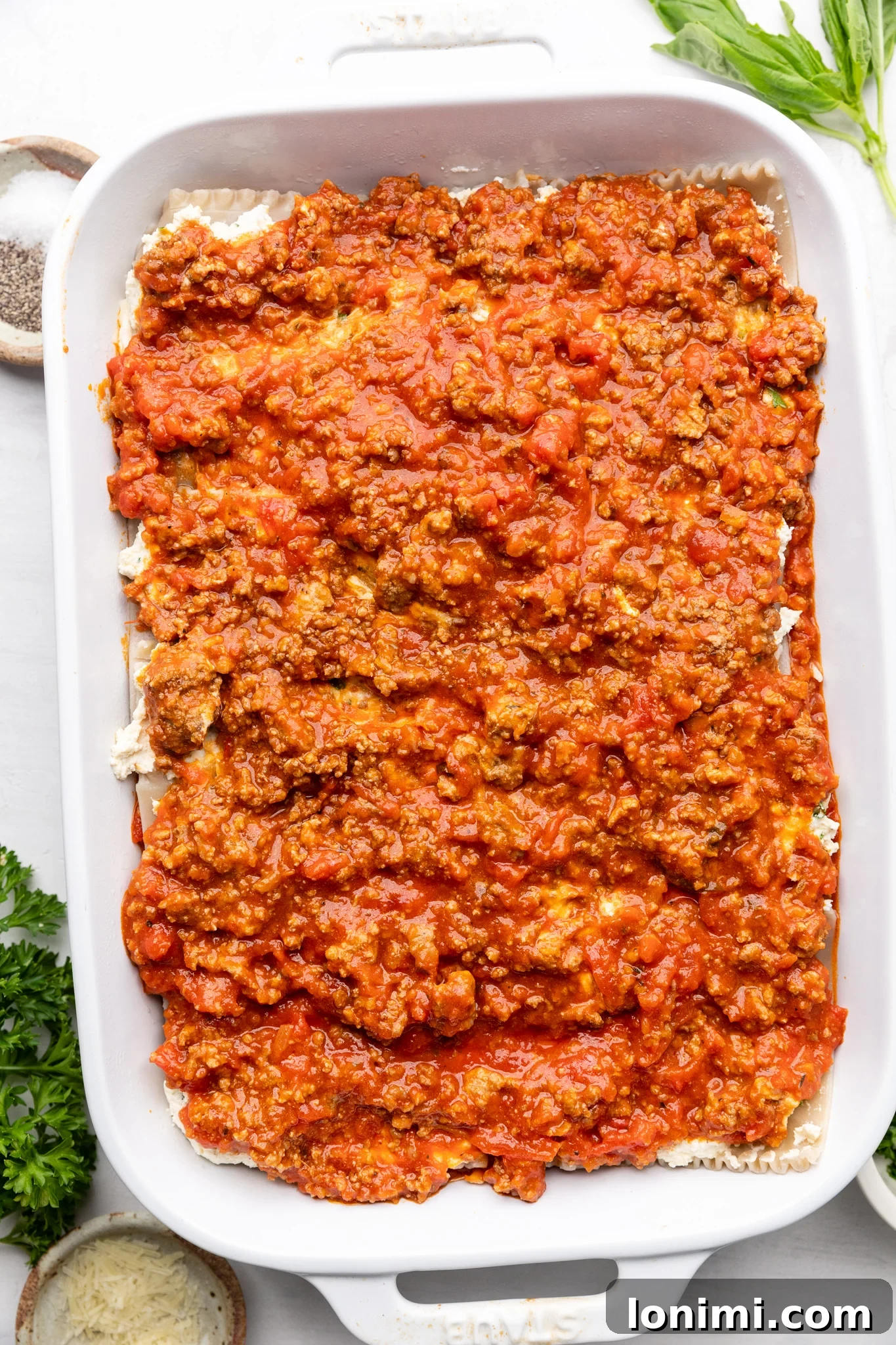 Effortless Allergen-Friendly Lasagna 6 Cross-section view of a perfectly layered gluten-free lasagna in a white casserole dish, showcasing the meat, cheese, and noodle layers