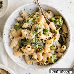 One Pot Gluten Free Broccoli Mac and Cheese in a bowl with parmesan cheese and a spoon
