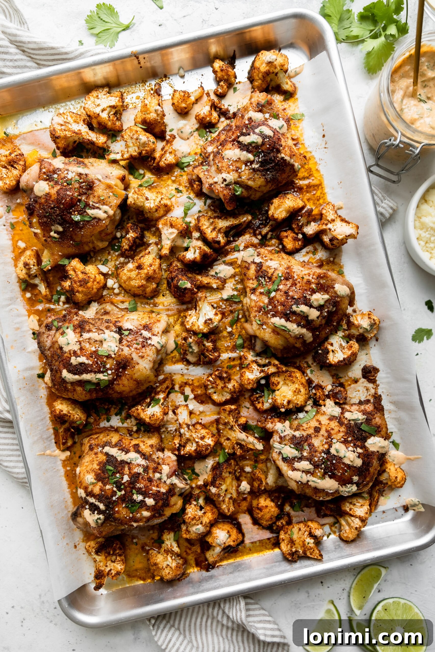 Sheet Pan Fiesta Bowls with Chicken and Roasted Cauliflower 2 a silver sheet pan with roasted cauliflower and chicken thighs