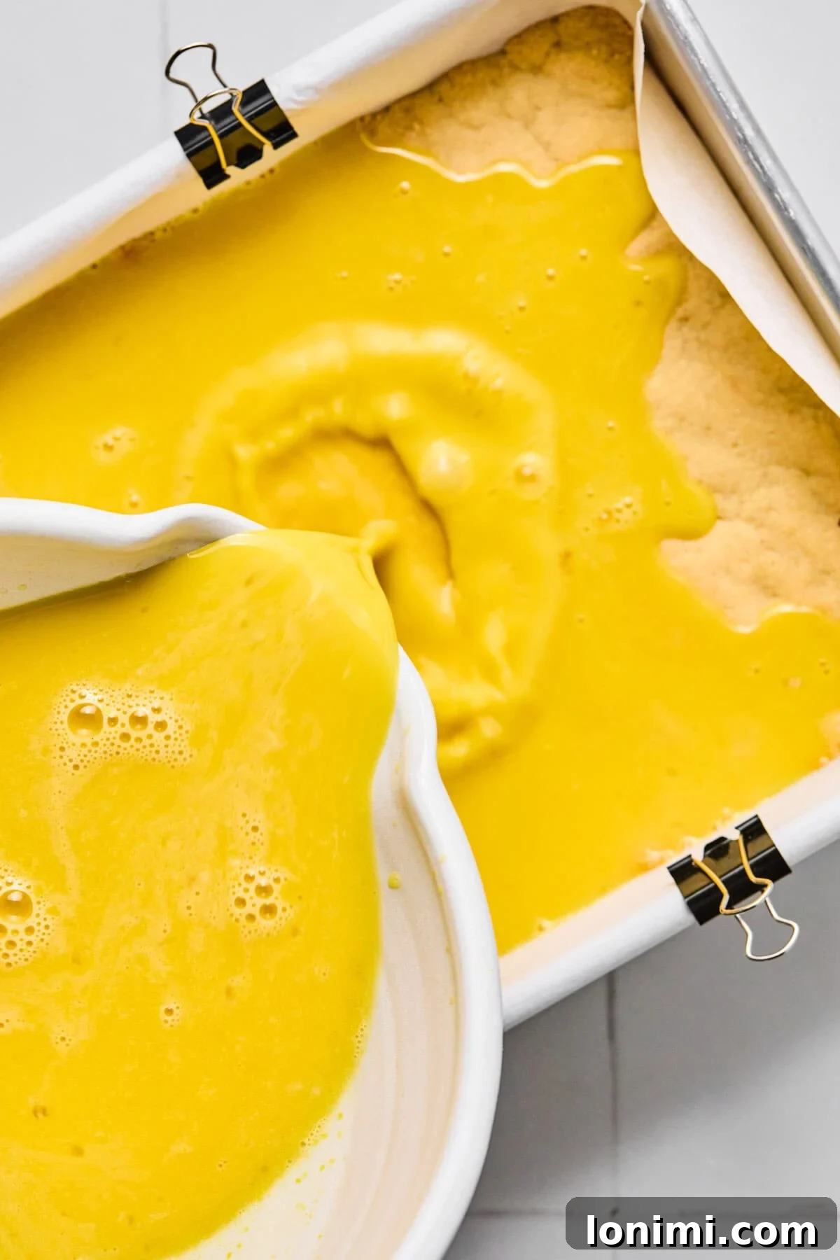 lemon filling being poured over crust