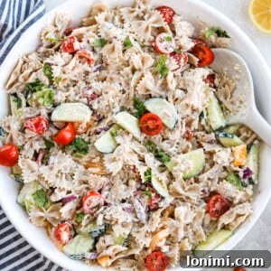Healthy Tuna Pasta Salad in a white bowl with veggies and a white spoon