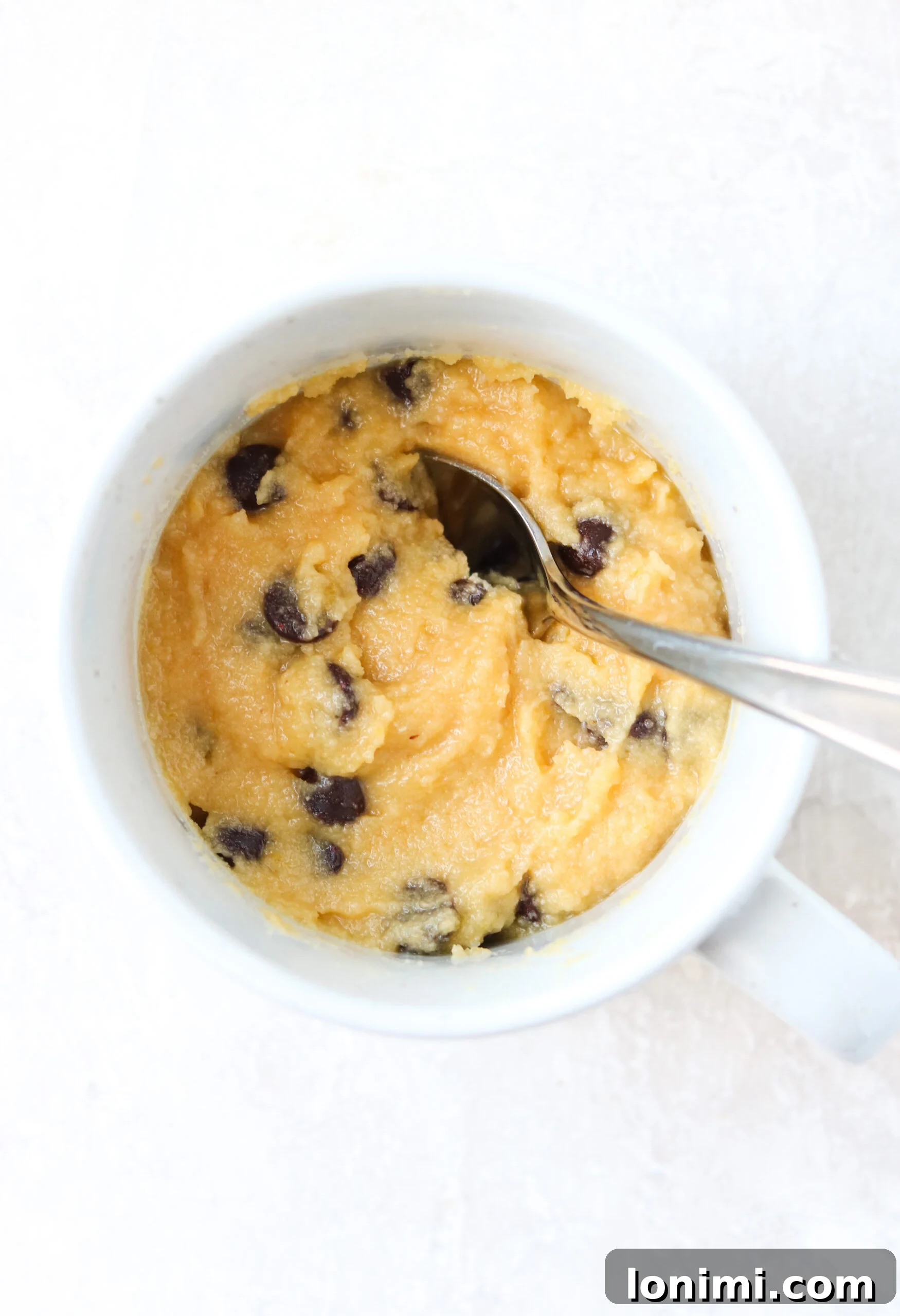 Raw gluten-free mug cake batter in a cup, ready to be microwaved or baked.
